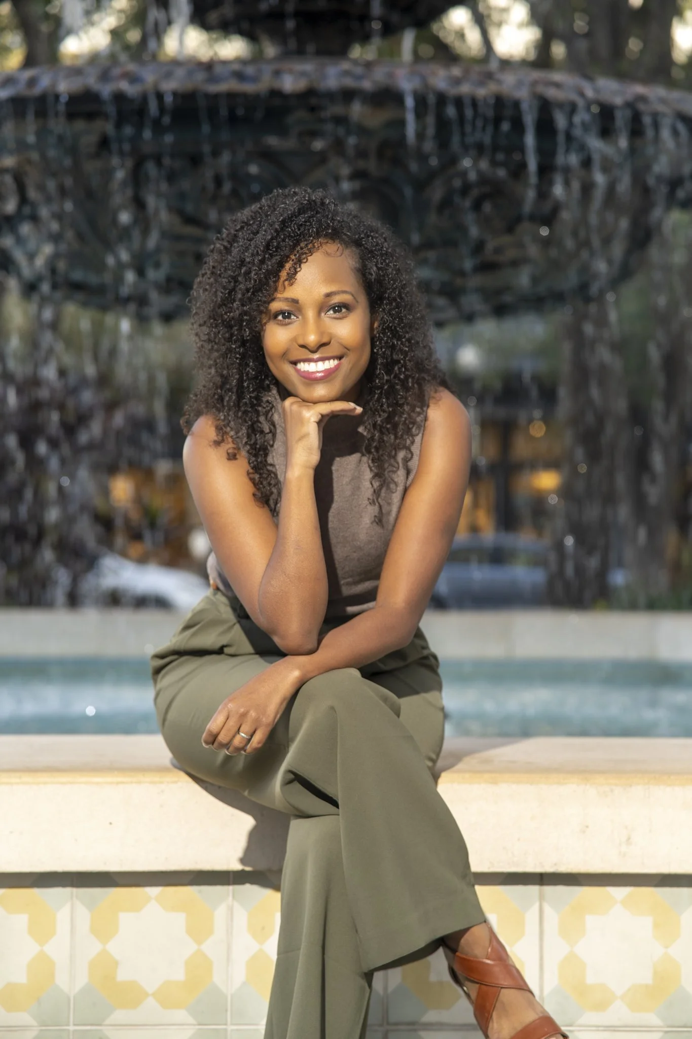 green pants, brown shirt, waterfall, black women, curly hair