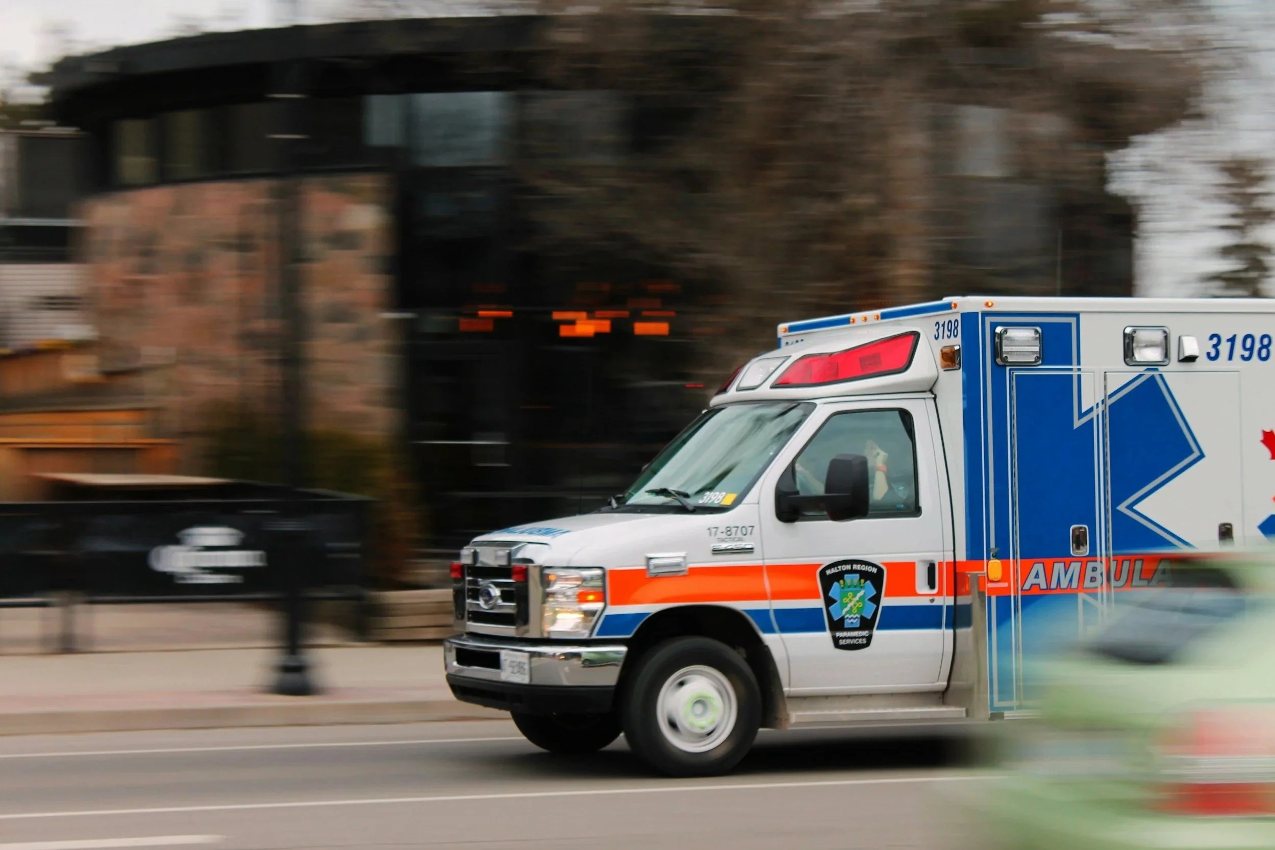 Ambulance driving through city streets, representing the pressure, urgency, and emotional toll carried by high-functioning first responders.