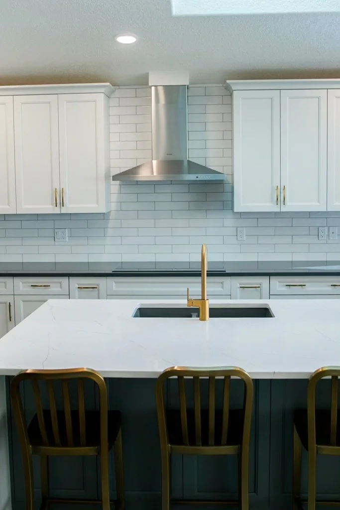 Royal Oak Calgary kitchen after renovation with white shaker cabinets, gold fixtures, and quartz countertops