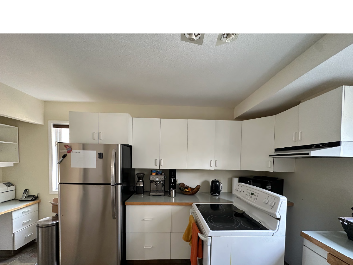 Before Canmore kitchen renovation with outdated white cabinets and laminate countertops