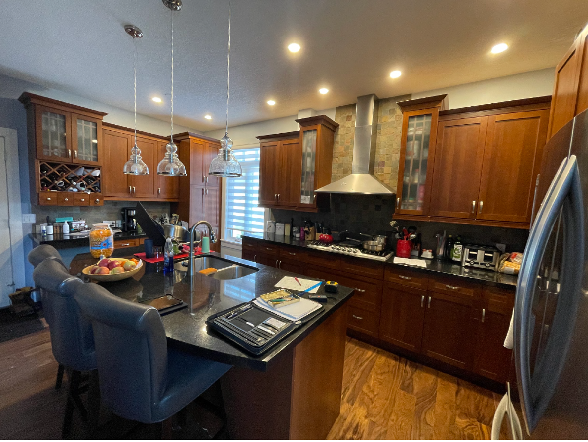 Calgary kitchen before renovation with dark wood cabinets, granite counters, and traditional finishes.