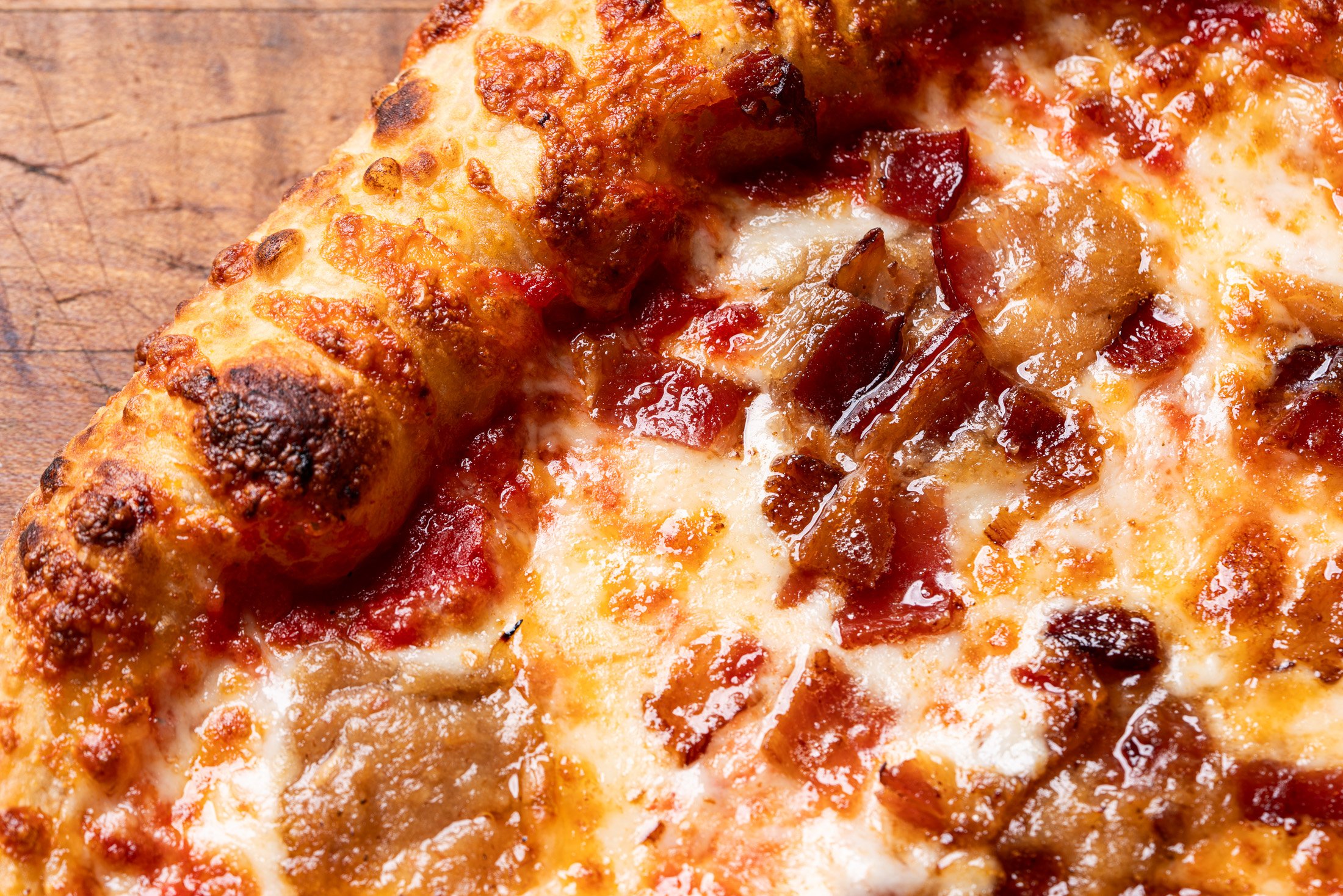 detailed view of the perfectly baked crust, mozzarella cheese, bacon jam, and bacon on the Bacon Jamming pizza