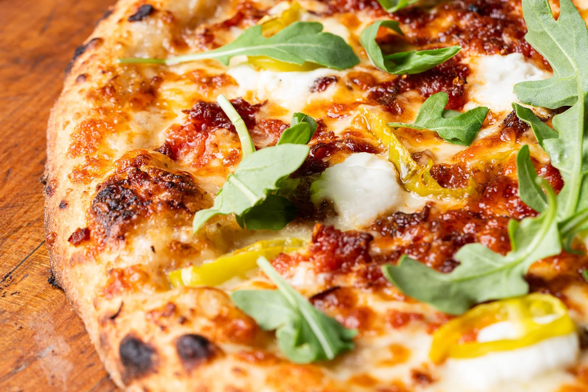 Detailed view of the perfectly baked sourdough pizza crust and delicious toppings on the Notorious P.I.G. special.