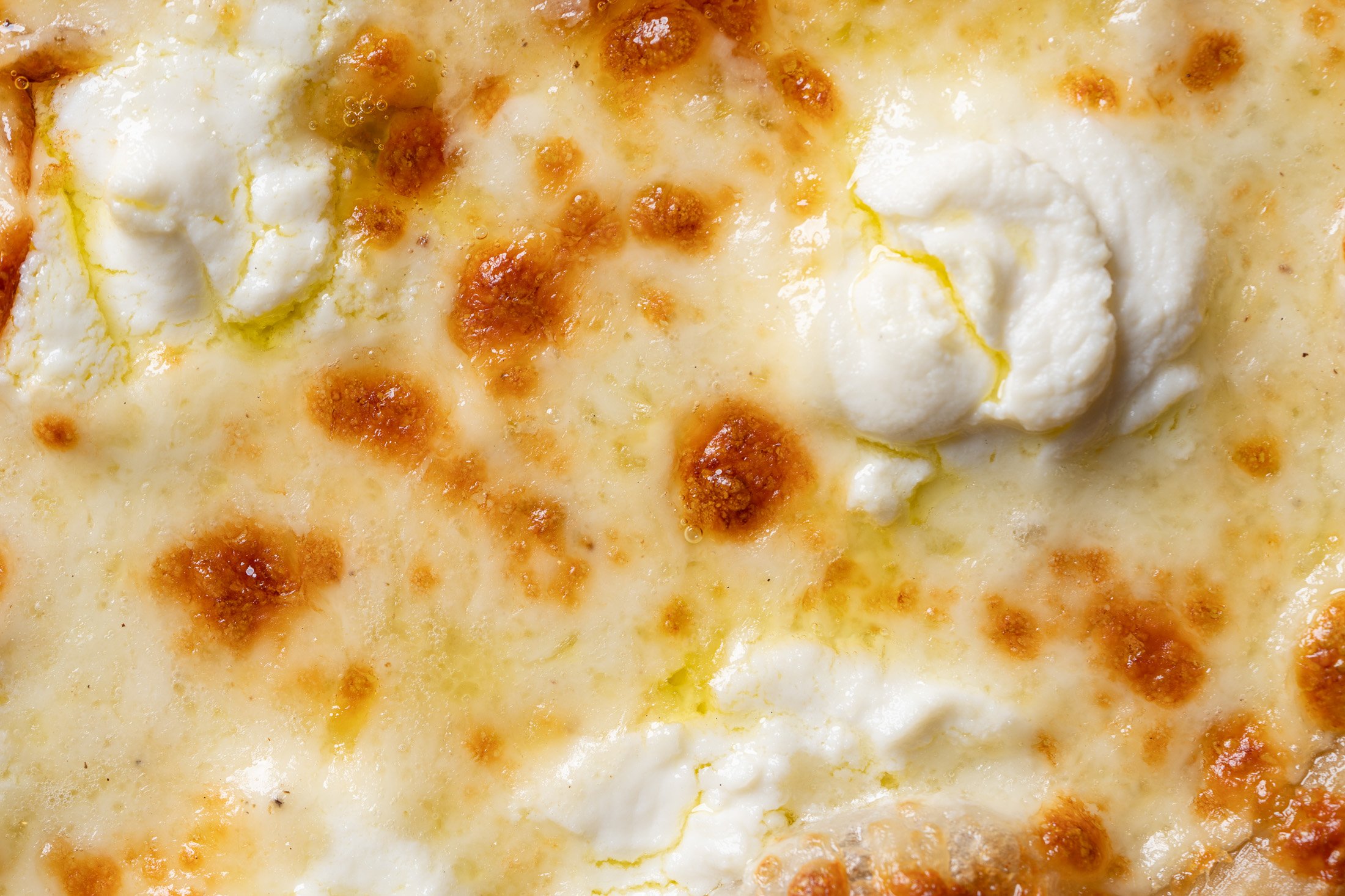 detail view of perfectly baked mozzarella, ricotta, and olive oil