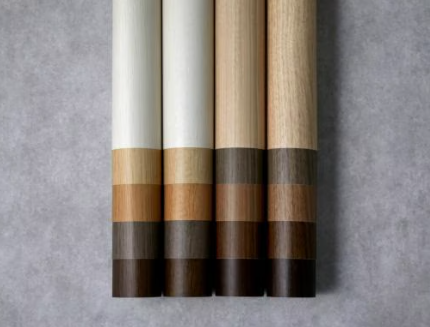 Four wooden pencils with white, beige, and dark brown eraser ends, arranged on a gray surface.