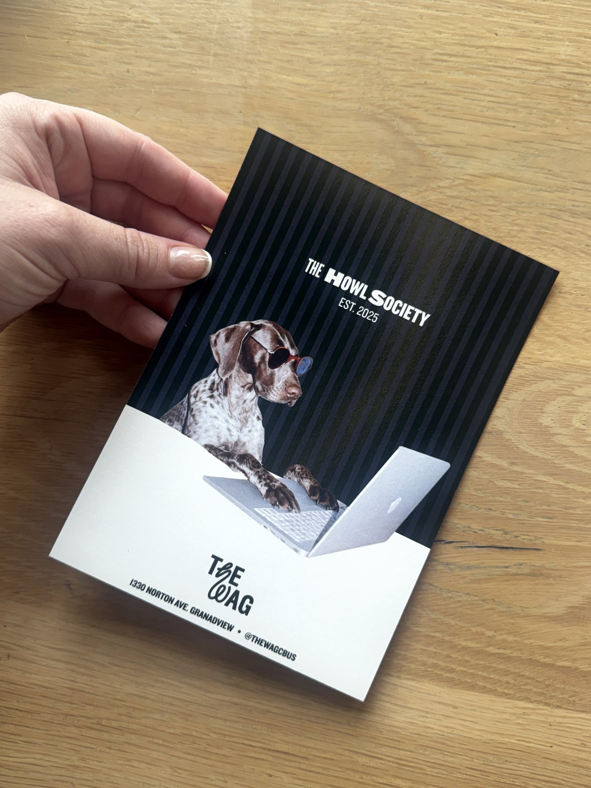 Flyer for The Howl Society featuring a dog wearing sunglasses, sitting at a laptop computer, with a black and white background.