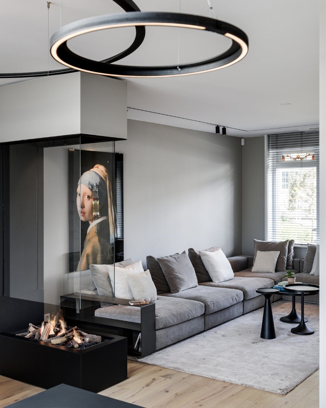 This modern fireplace is the epitome of minimalist design, seamlessly blending with the sophisticated interior of a contemporary home. Its frameless, glass-enclosed firebox offers an unobstructed view of the dancing flames, creating a mesmerizing vis