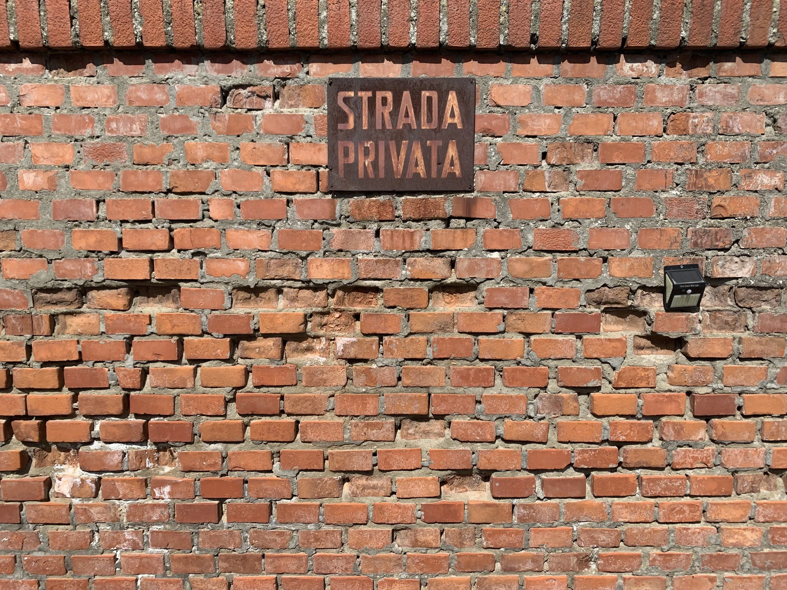 Cartello «Strada privata» su un muro di mattoni. copyright "Tommaso Scavone"