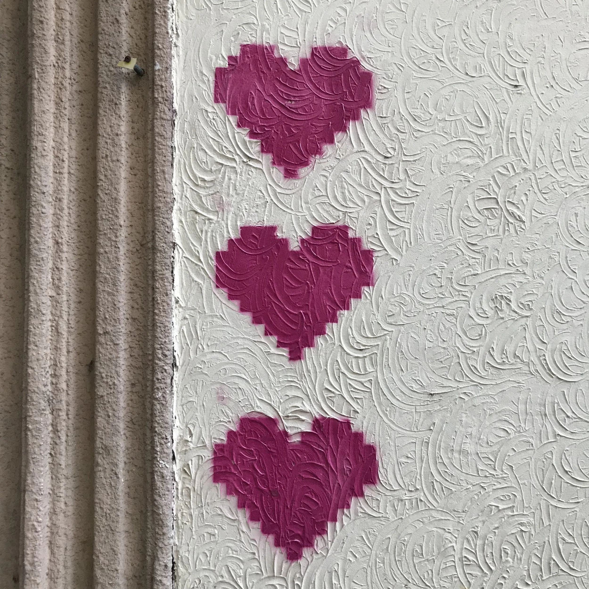 Vignetta di graffiti di un cuore rosa su una parete bianca con un motivo decorativo