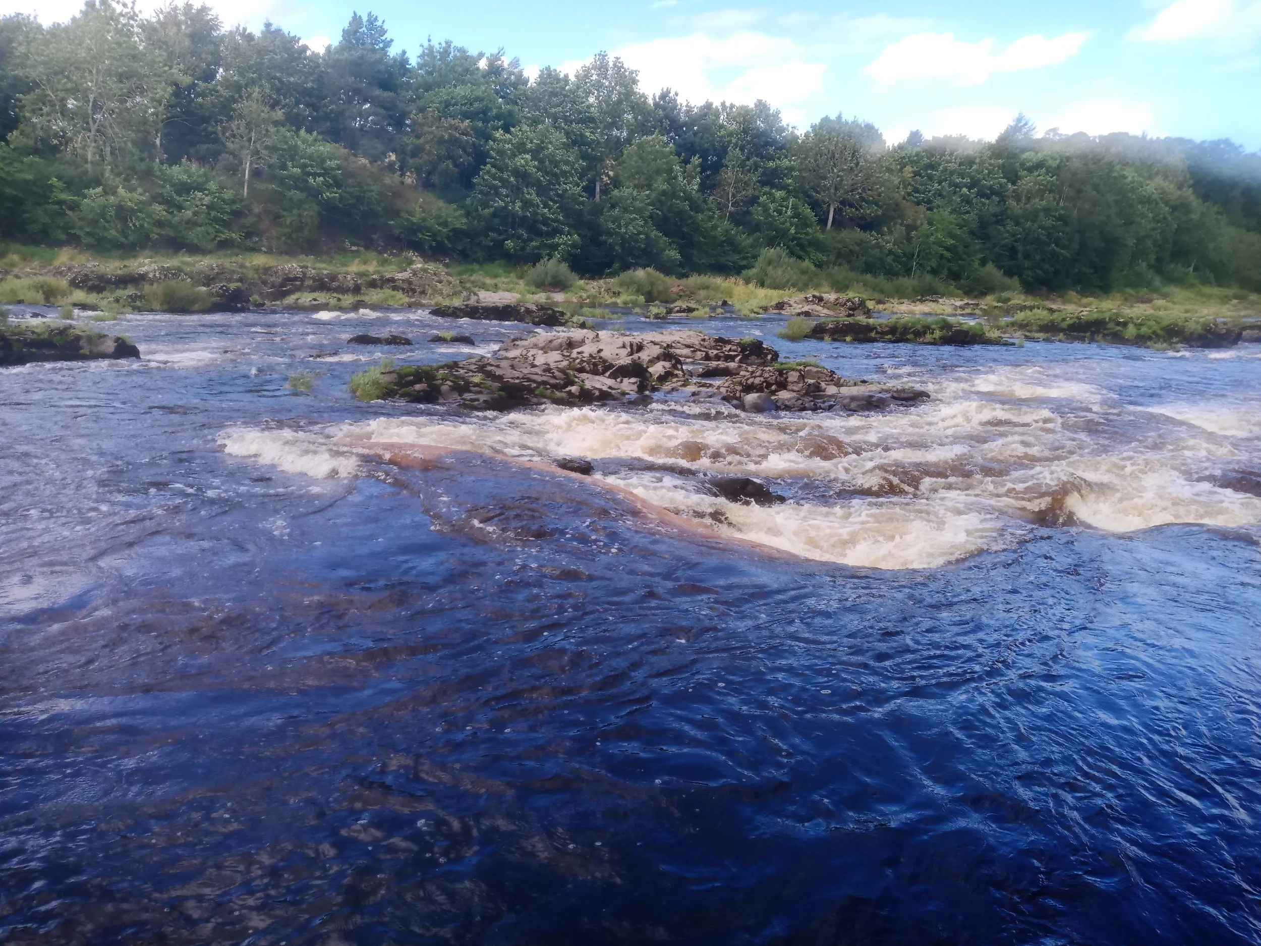 Disaster! I misjudged a set of rapids and got the boat lodged firmly on a rock. She is in frame, just with water flowing over every surface!