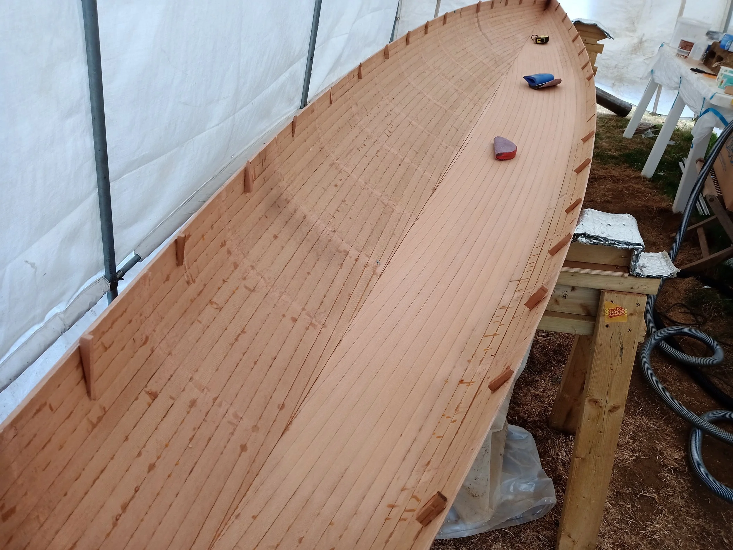 This unbonded parting line enables separation of the deck and hull to enable fairing the inside of the hull. Notice the small cedar alignment dogs, hot glued to the inside of both deck and hull.