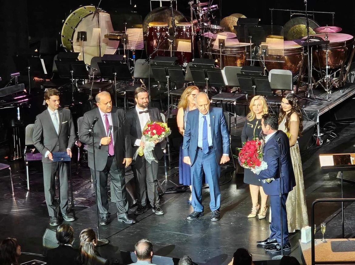 AHI President Nick Larigakis, Chairman James Lagos, Board Member Maria Wills, and staff present Mario Frangoulis with a gift and a bouquet after his performance on April 12, 2024. 