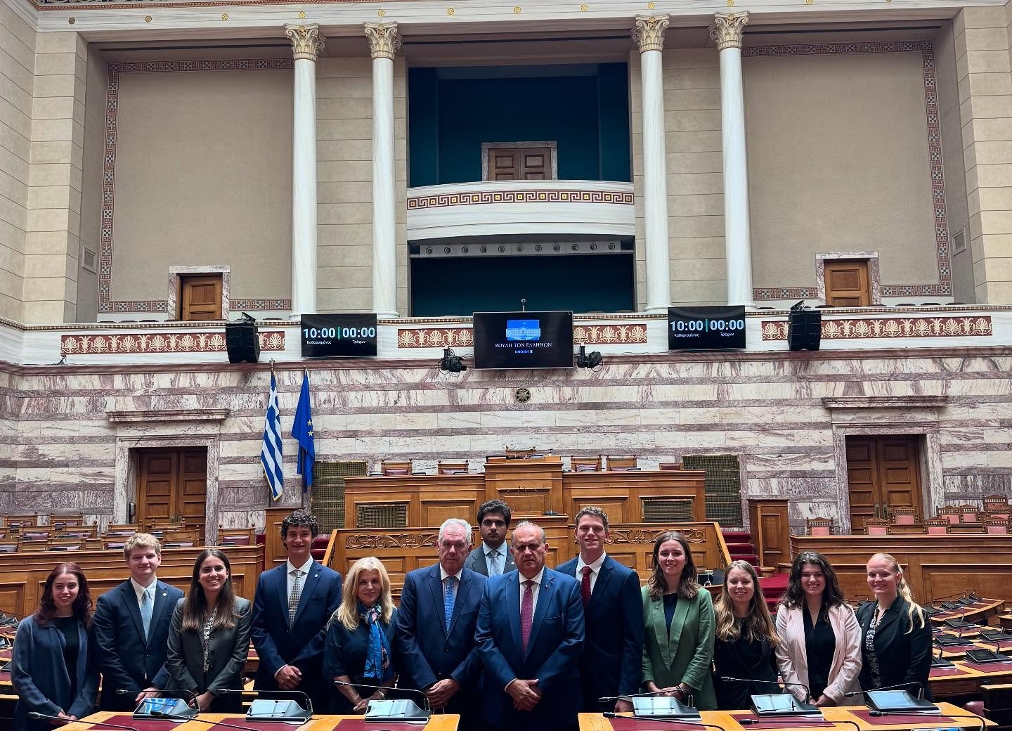 AHI President Nick Larigakis (center) with AHI Athens Chapter President Vice Admiral Vasileios Kyriazis (ret.) H.N. (to his right) and Maria Wills, AHI Board Member (to his right) with the students at the Hellenic Parliament.