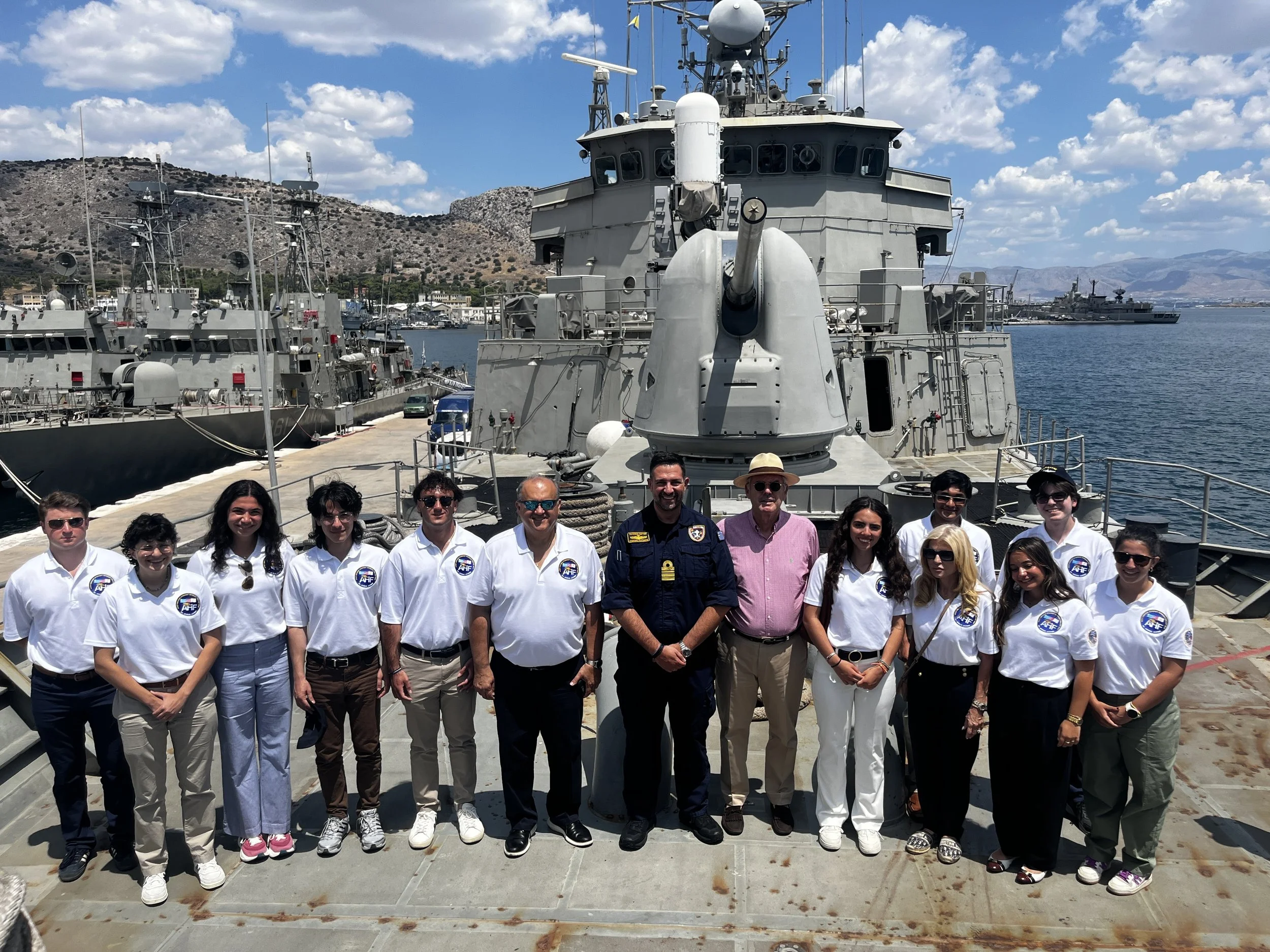  The students pose in front of the main gun of the frigate HS Hydra. 
