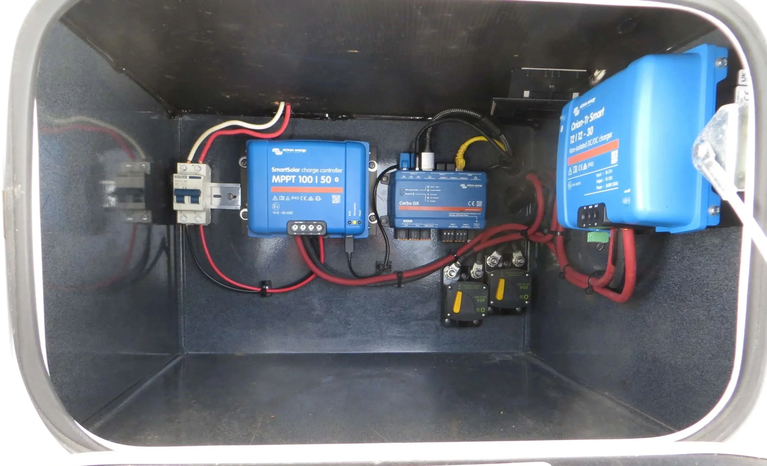 Open battery and control box cabinet with electrical components and wiring inside. Example of RV Solar Install near San Diego.  Lithium Battery, DC/DC Converter, LiFePO4, Inverter, install on RV near San Diego, CA.