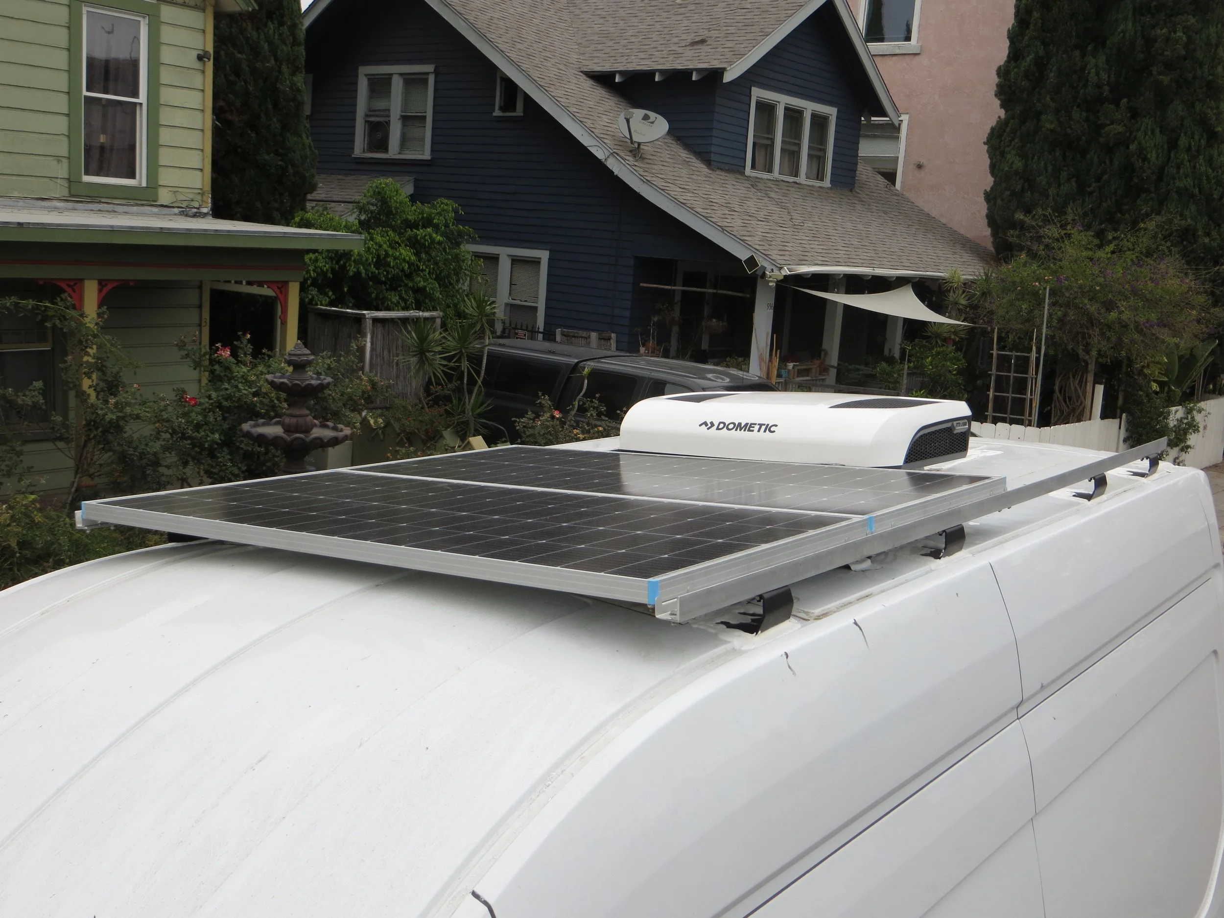 Solar panels installed on the roof of a white vehicle, likely a van, Example of RV Solar Install near San Diego.  Lithium Battery, DC/DC Converter, LiFePO4, Inverter, install on RV near San Diego, CA.
