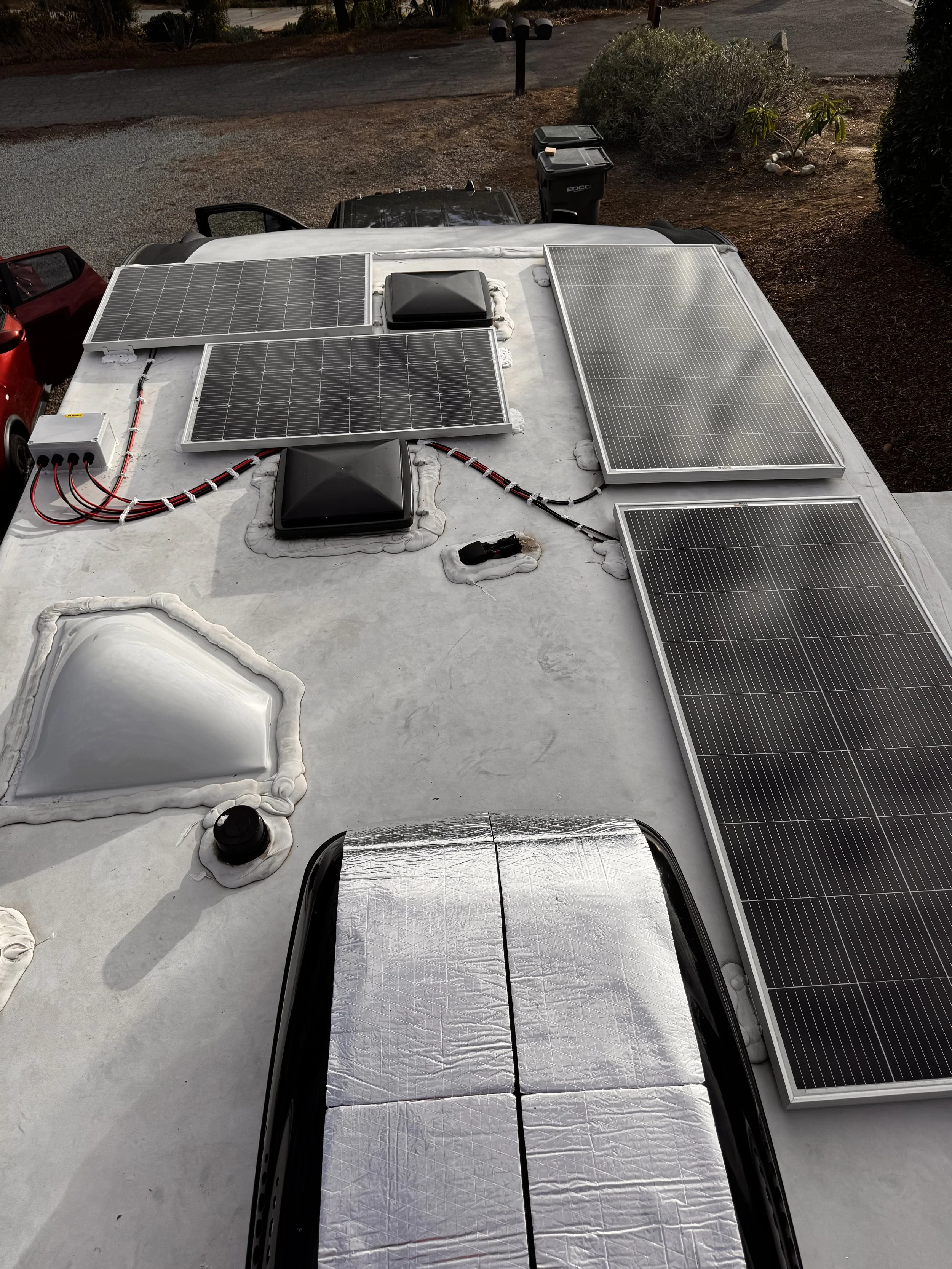 Roof of an RV with solar panels, vents, and electrical equipment. Example of RV Solar Install near San Diego.  Lithium Battery, DC/DC Converter, LiFePO4, Inverter, install on RV near San Diego, CA.