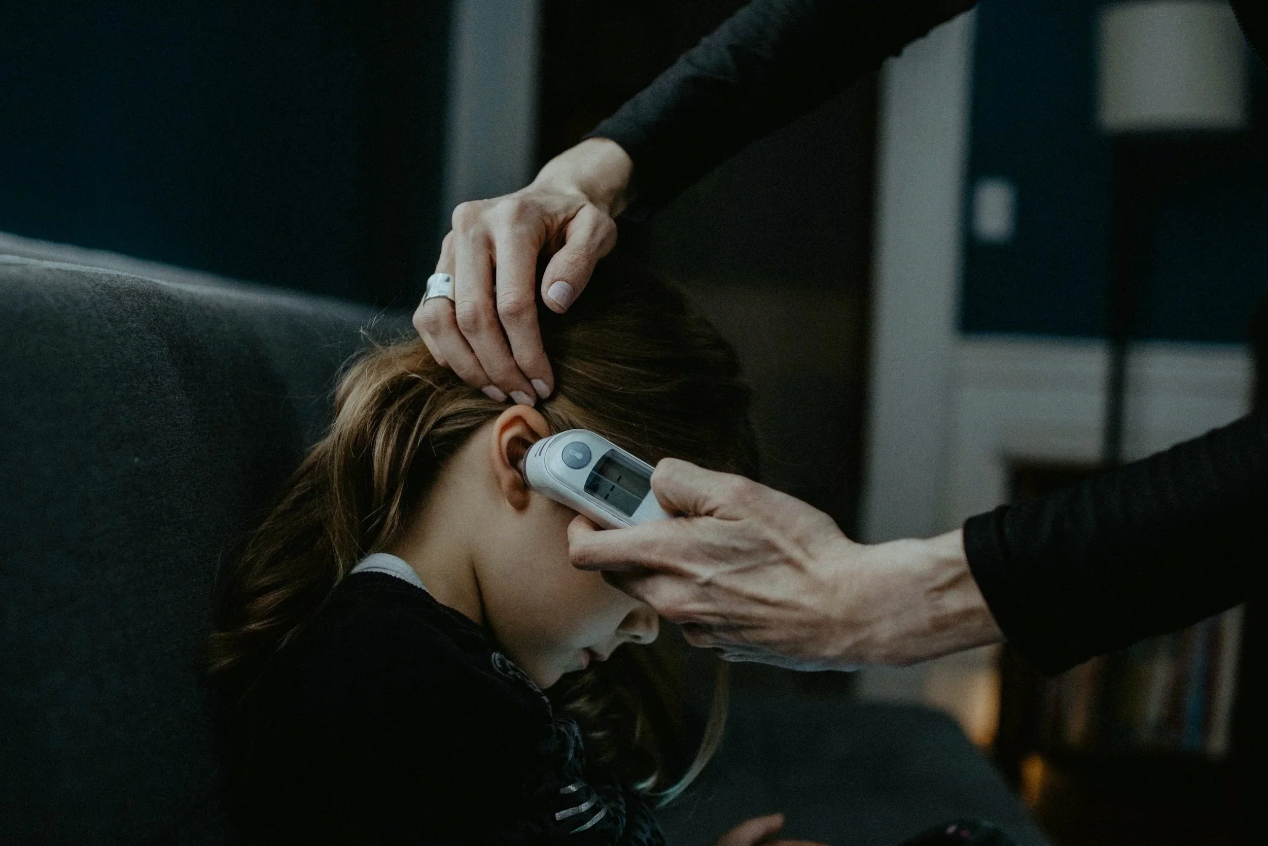 Parent checking child's temperature.