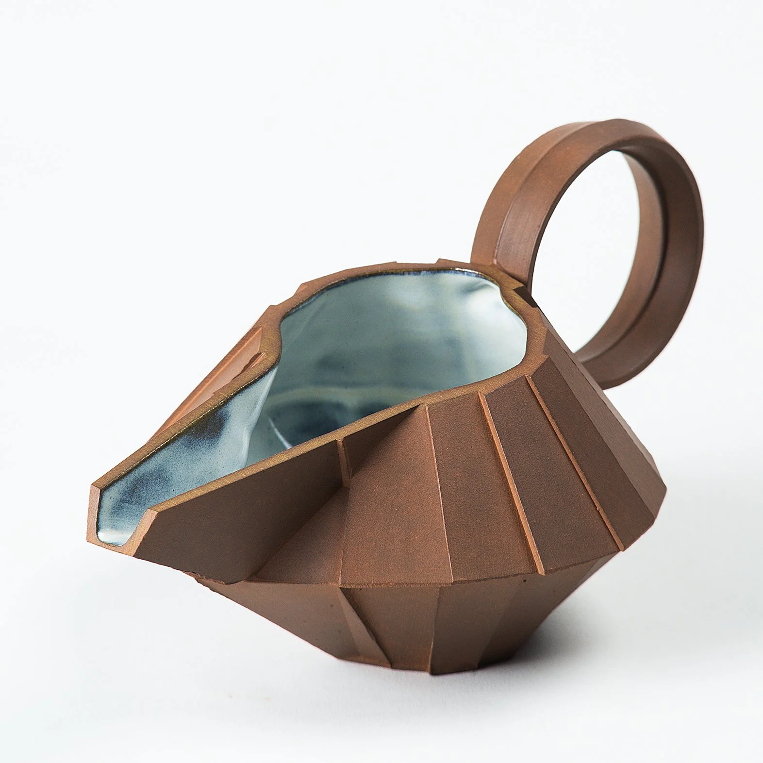 Handmade faceted ceramic gravy boat with unglazed red stoneware exterior and off-white glazed interior, by Lea & Nicolas