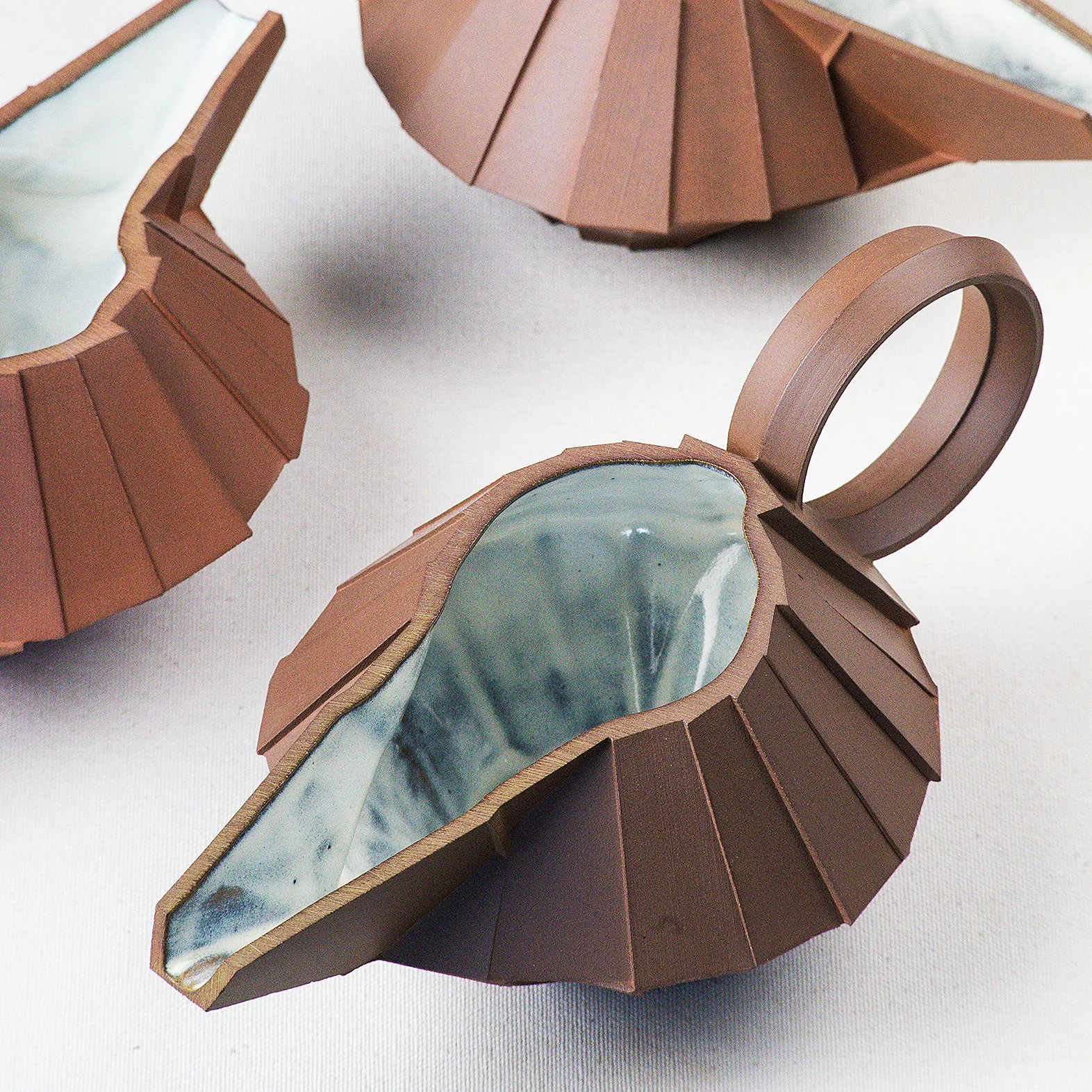 Handmade faceted ceramic gravy boat with unglazed red stoneware exterior and off-white glazed interior, by Lea & Nicolas