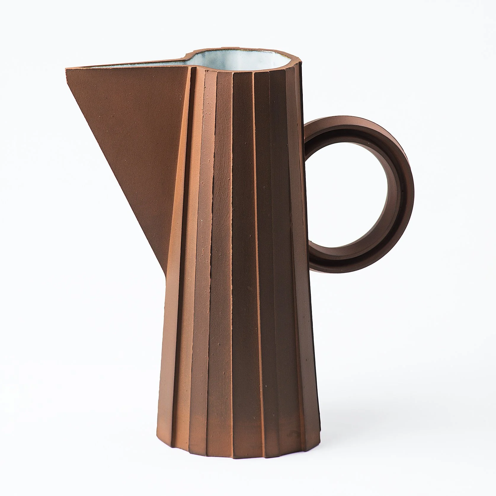 Handmade faceted ceramic pitcher with unglazed red stoneware exterior and off-white glazed interior, by Lea & Nicolas