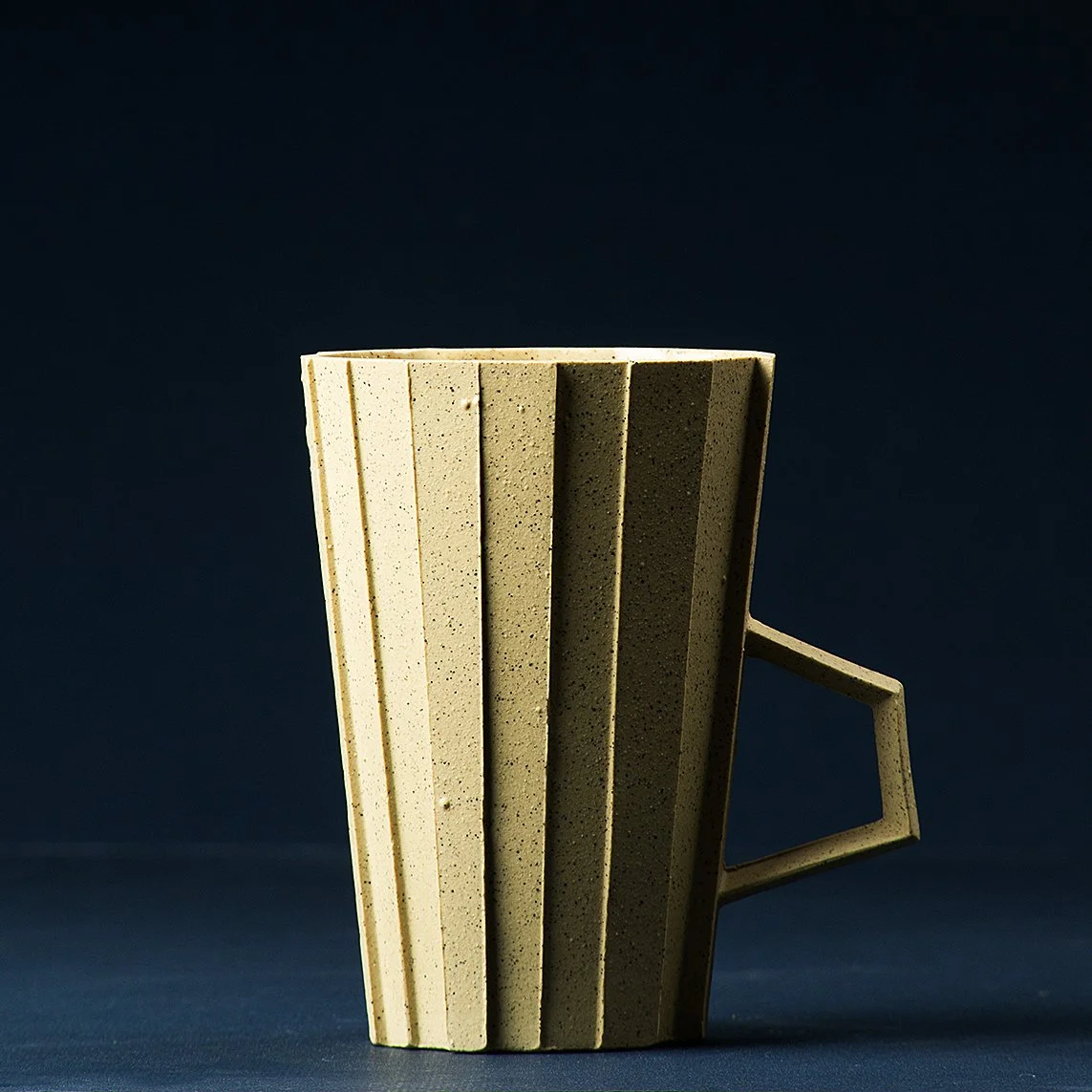 Handmade brutalist faceted ceramic cup in speckled yellow stoneware, by Lea & Nicolas