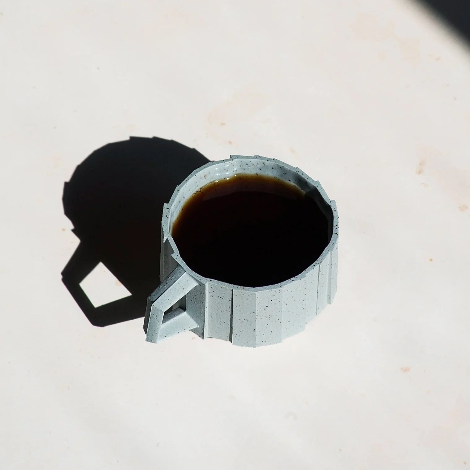 Handmade brutalist faceted ceramic cup in speckled blue stoneware, by Lea & Nicolas