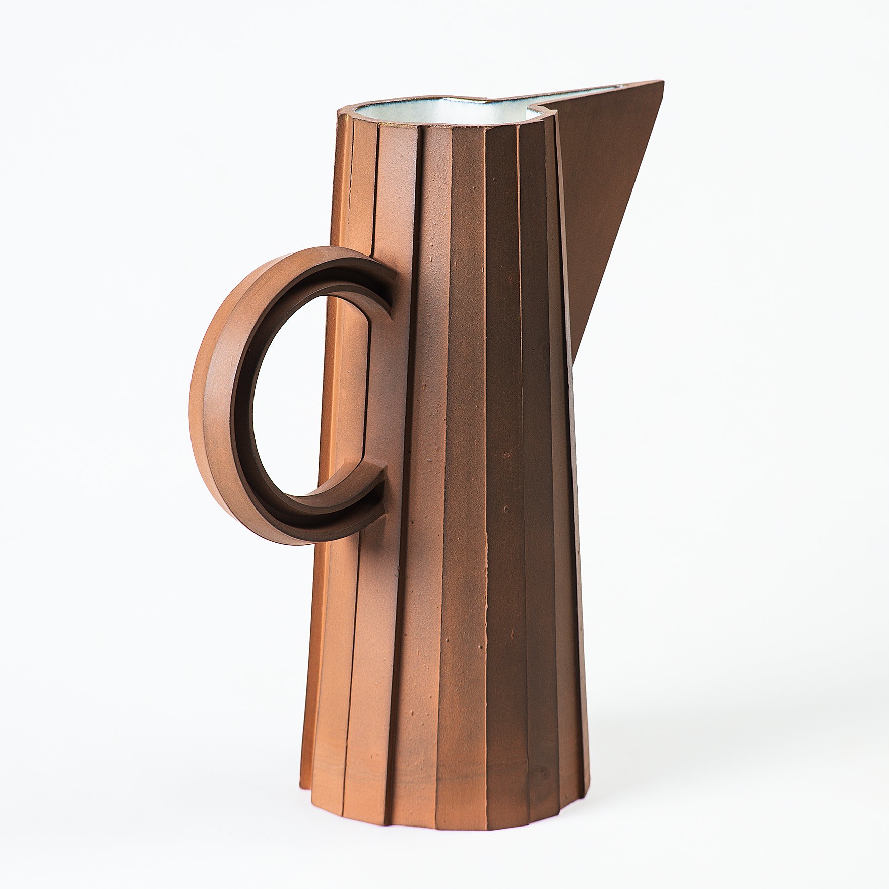 Handmade faceted ceramic pitcher with unglazed red stoneware exterior and off-white glazed interior, by Lea & Nicolas