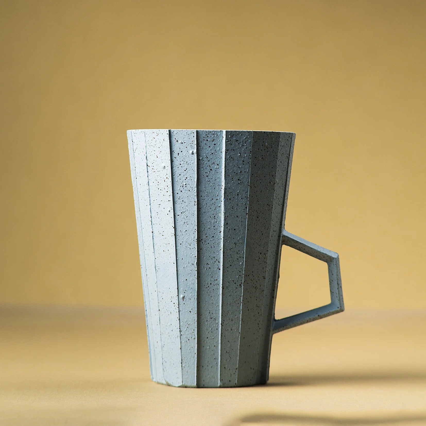 Handmade brutalist faceted ceramic cup in speckled blue stoneware, by Lea & Nicolas