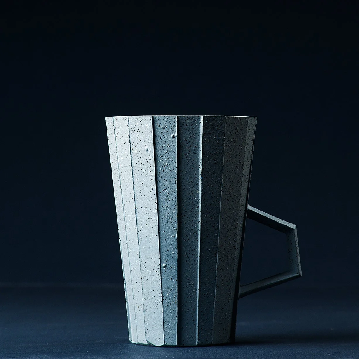 Handmade brutalist faceted ceramic cup in speckled blue stoneware, by Lea & Nicolas