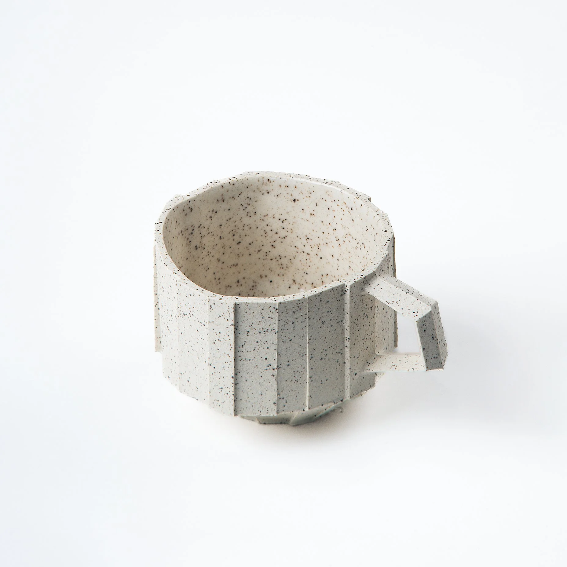 Handmade brutalist faceted ceramic cup in speckled white stoneware, by Lea & Nicolas