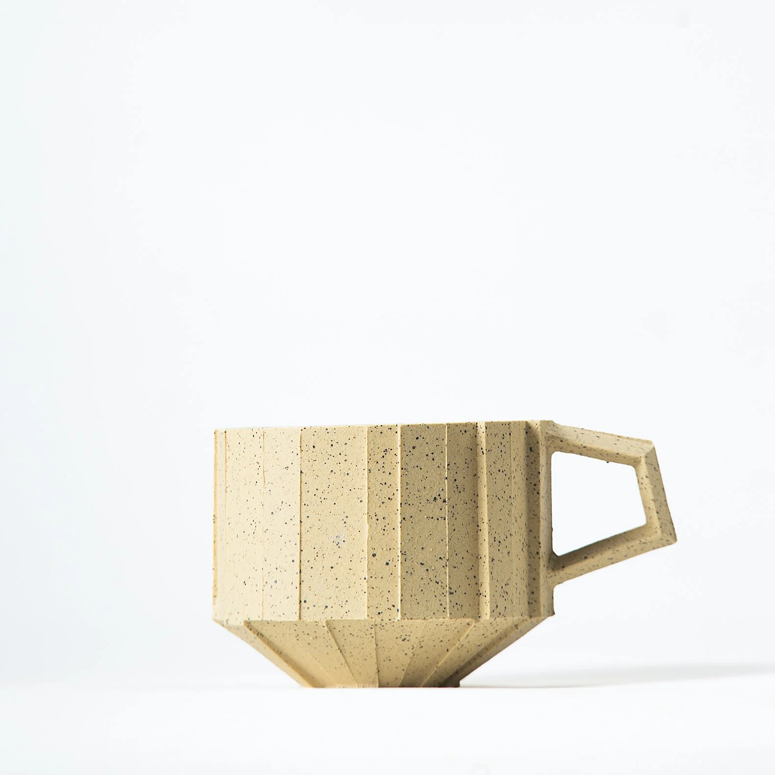 Handmade brutalist faceted ceramic cup in speckled yellow stoneware, by Lea & Nicolas