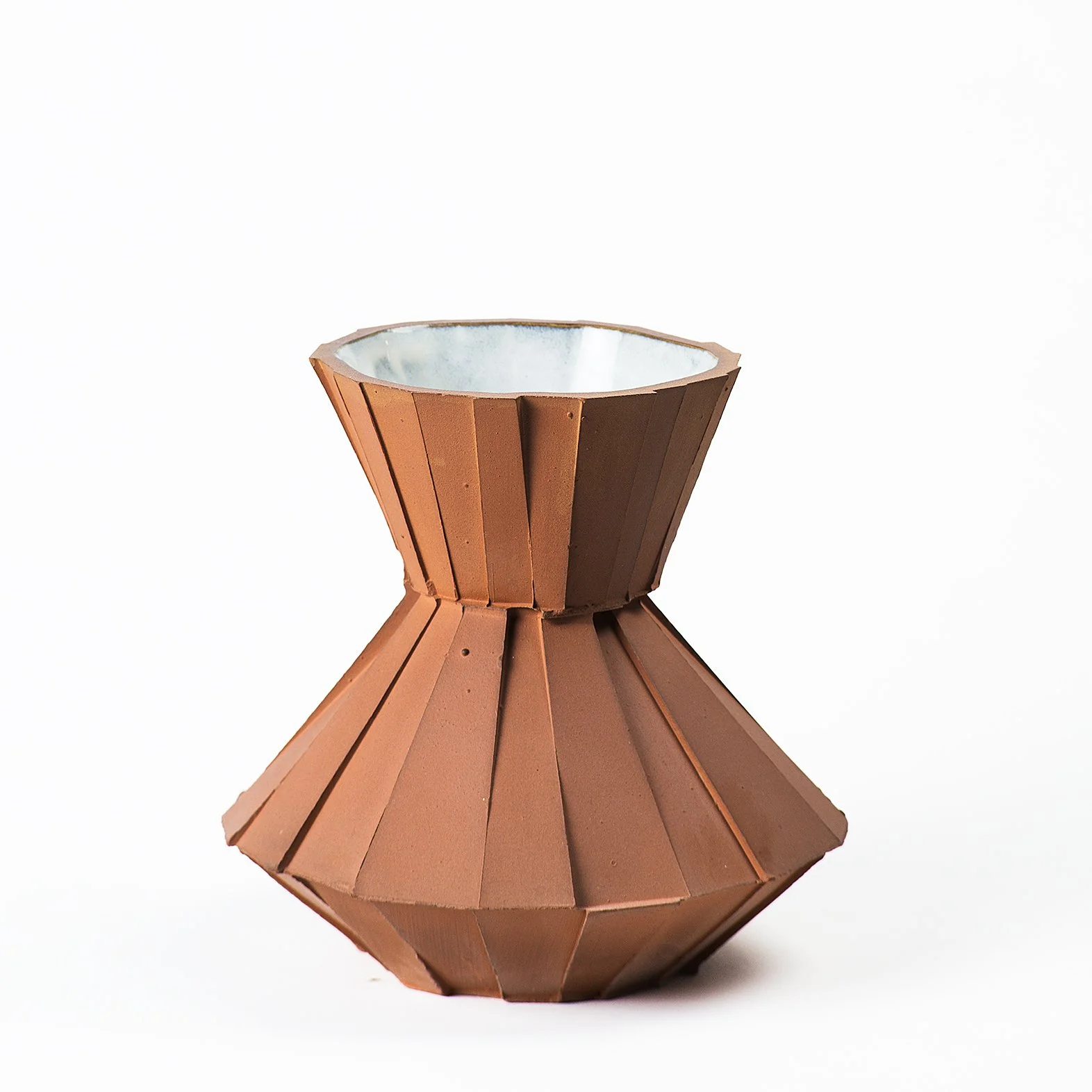 Handmade faceted ceramic carafe with unglazed red stoneware exterior and off-white glazed interior, by Lea & Nicolas