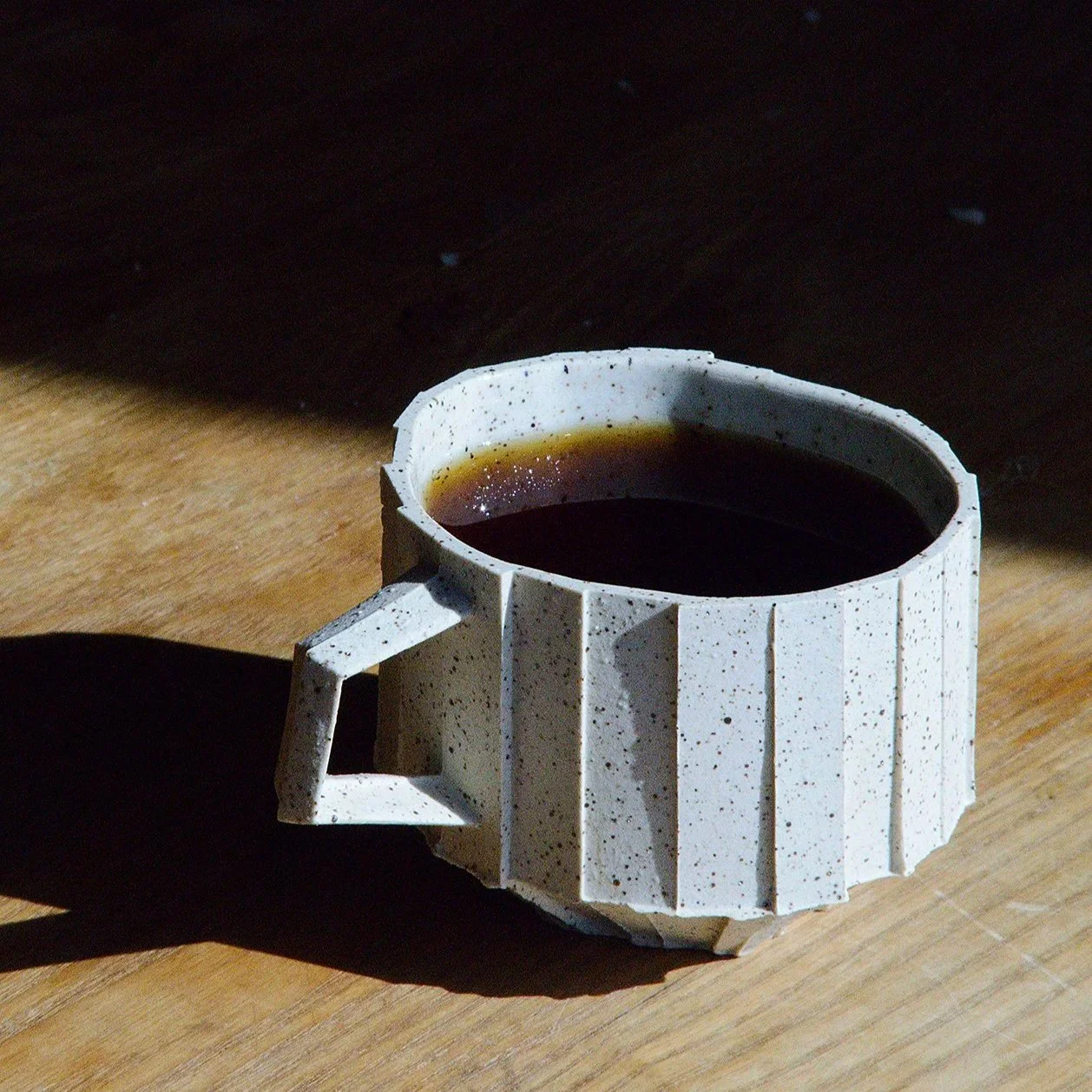 Handmade brutalist faceted ceramic cup in speckled white stoneware, by Lea & Nicolas