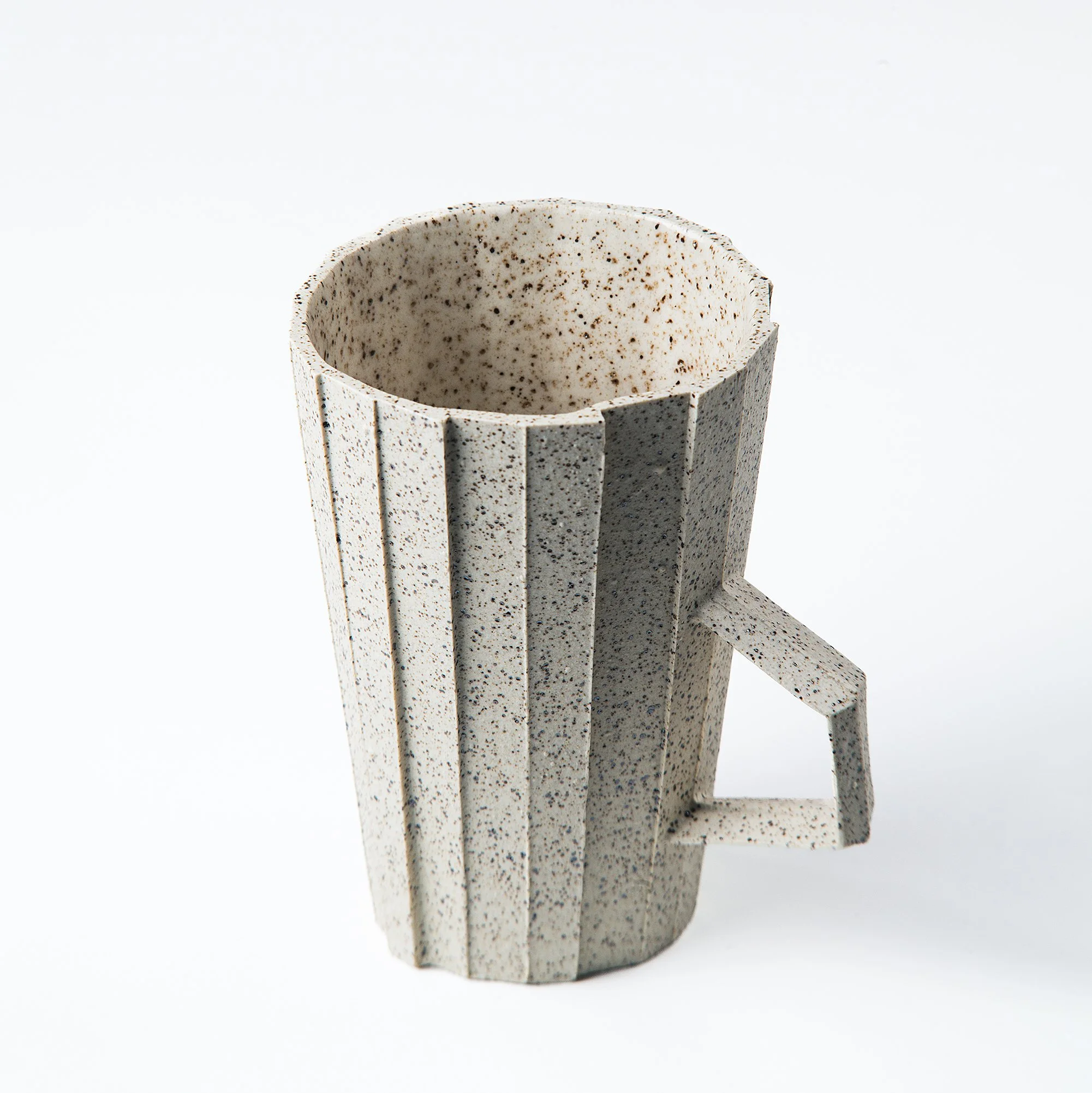 Handmade brutalist faceted ceramic cup in speckled white stoneware, by Lea & Nicolas