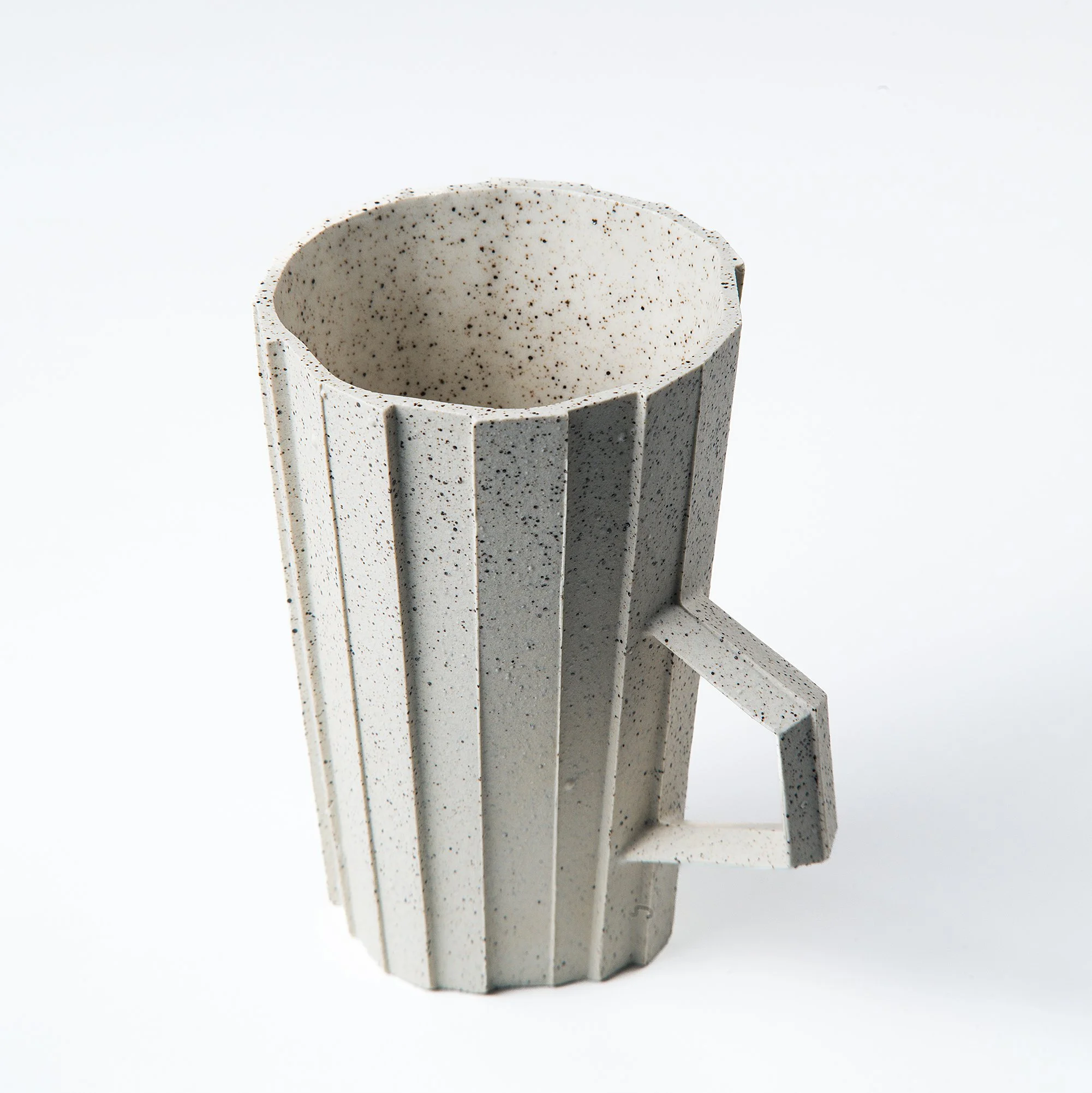 Handmade brutalist faceted ceramic cup in speckled white stoneware, by Lea & Nicolas