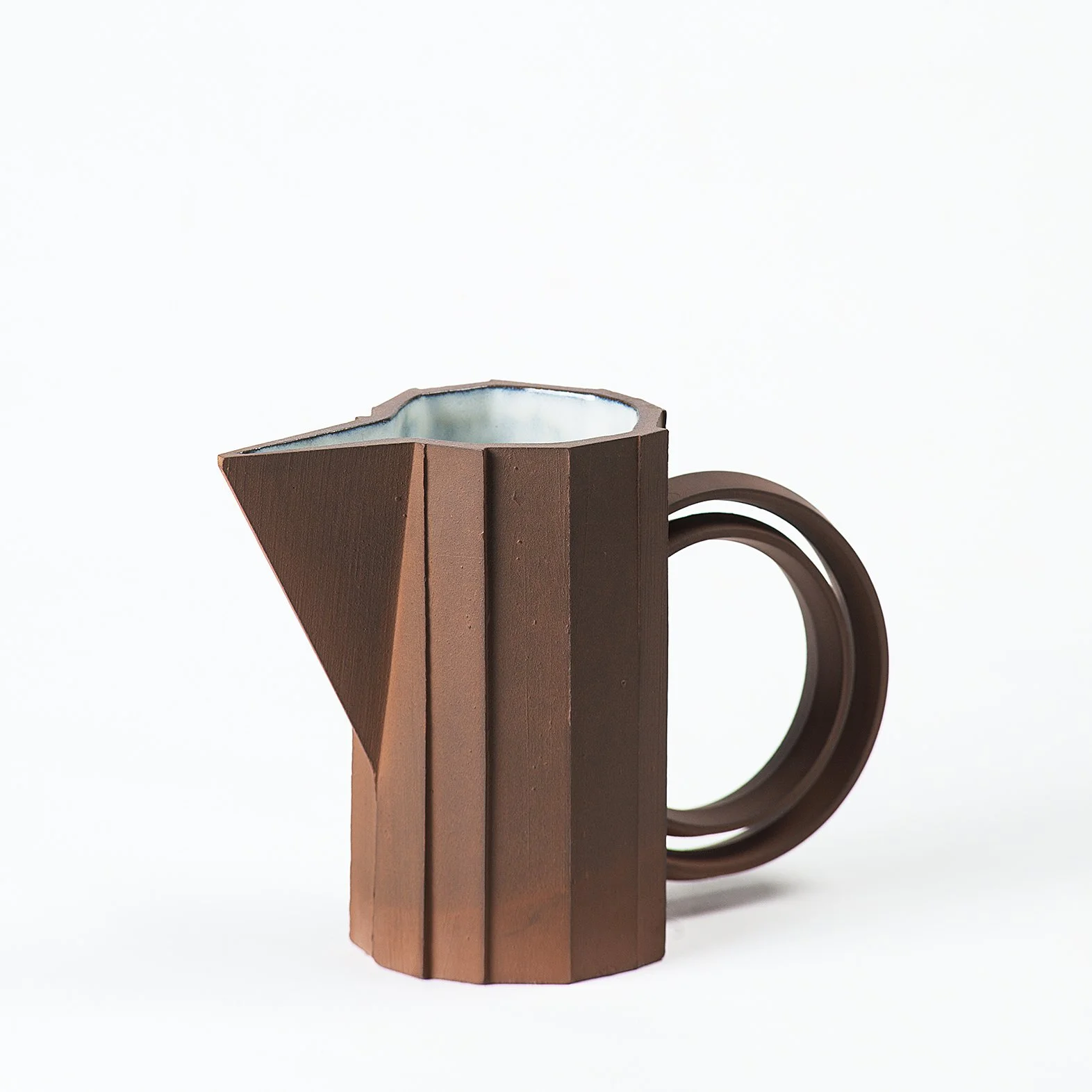Handmade faceted ceramic pitcher with unglazed red stoneware exterior and off-white glazed interior, by Lea & Nicolas