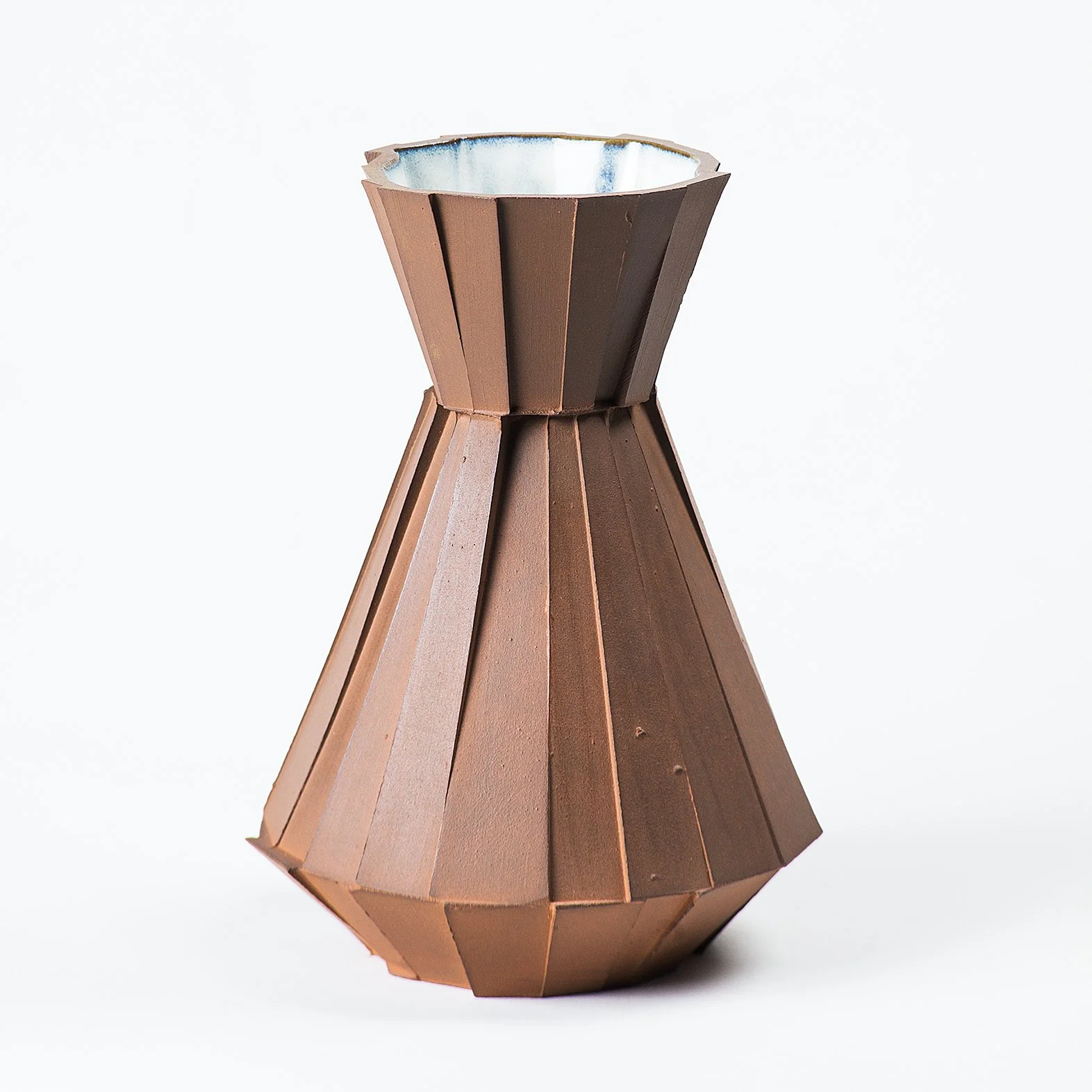 Handmade faceted ceramic carafe with unglazed red stoneware exterior and off-white glazed interior, by Lea & Nicolas