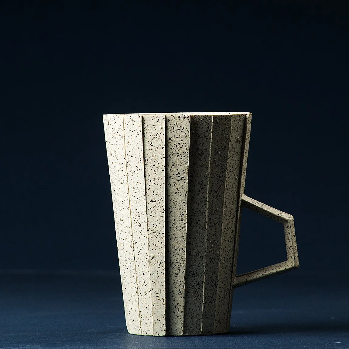 Handmade brutalist faceted ceramic cup in speckled white stoneware, by Lea & Nicolas