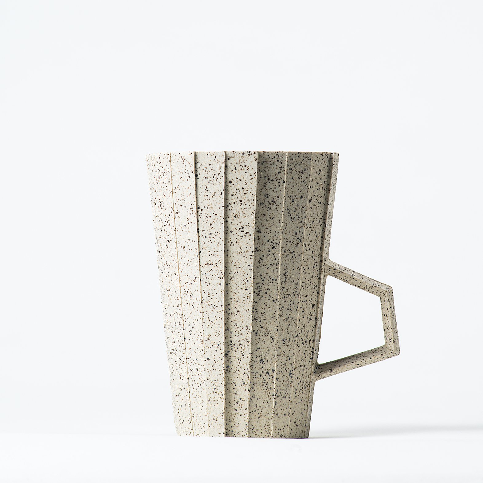 Handmade brutalist faceted ceramic cup in speckled white stoneware, by Lea & Nicolas