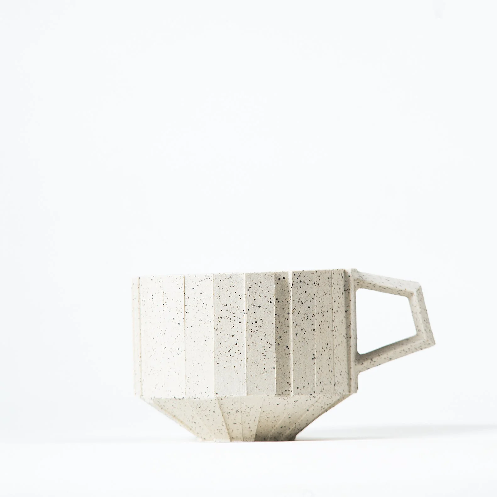 Handmade brutalist faceted ceramic cup in speckled white stoneware, by Lea & Nicolas