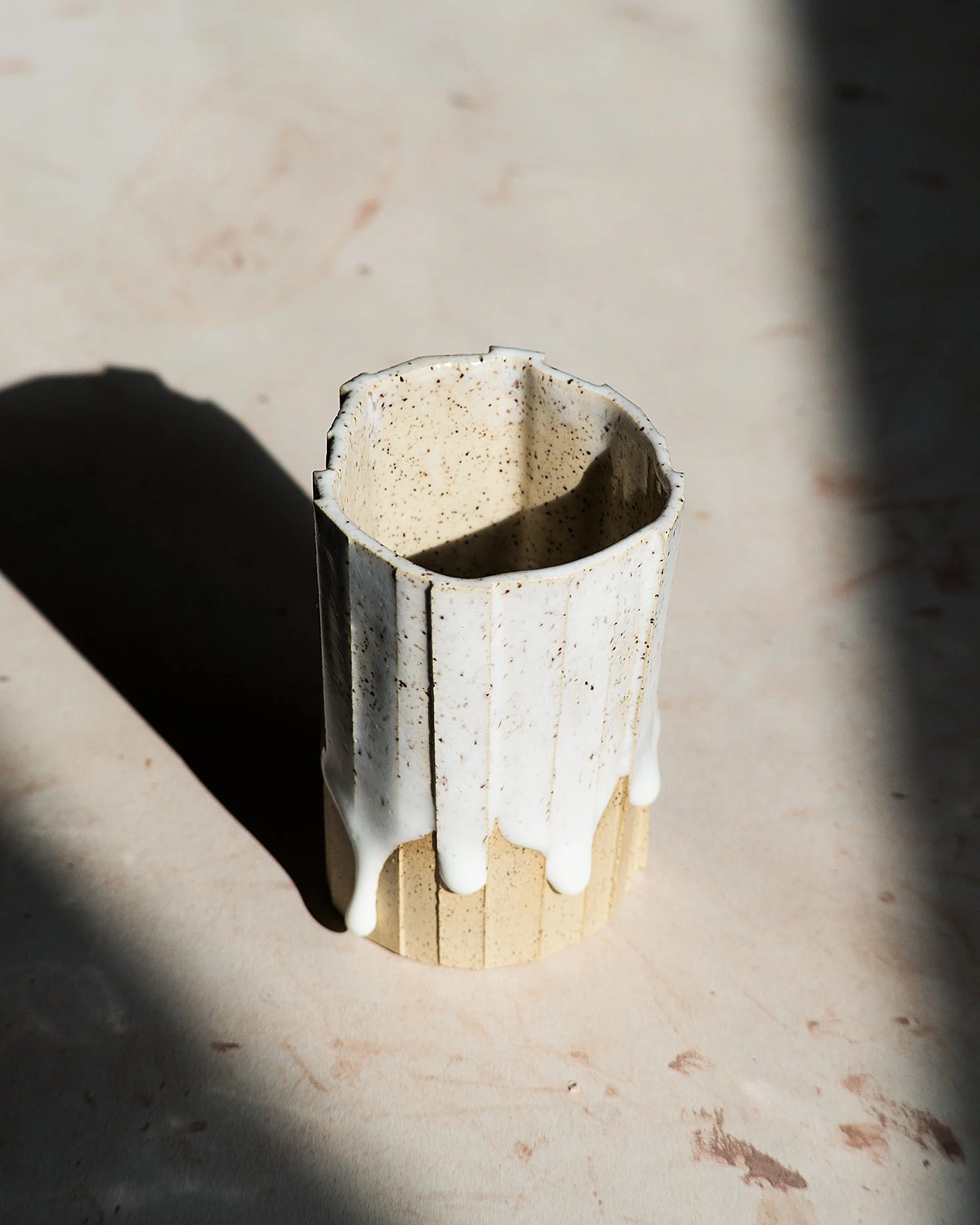 Handmade brutalist faceted ceramic tumbler, speckled white stoneware and drippy glaze, by Lea & Nicolas