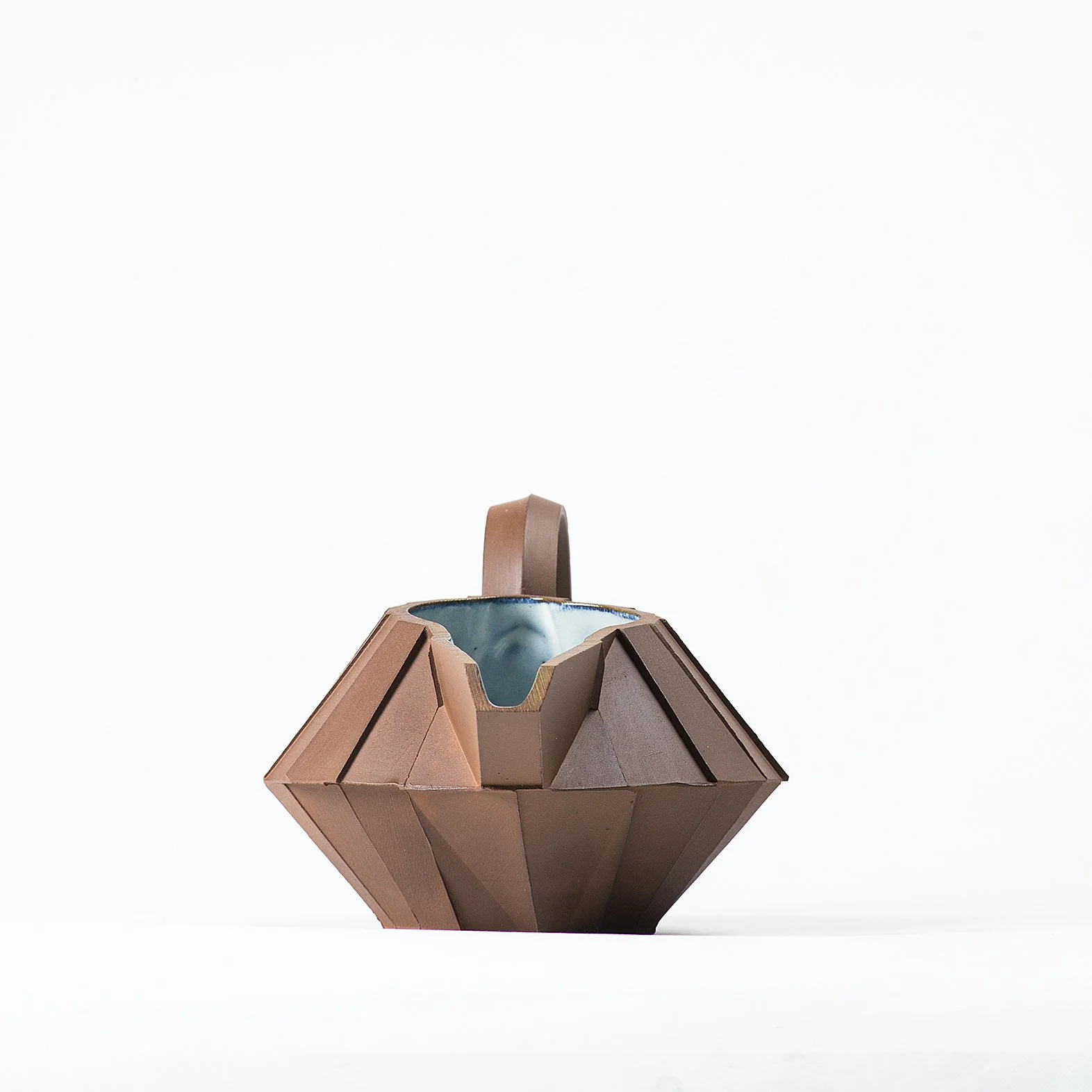 Handmade faceted ceramic gravy boat with unglazed red stoneware exterior and off-white glazed interior, by Lea & Nicolas