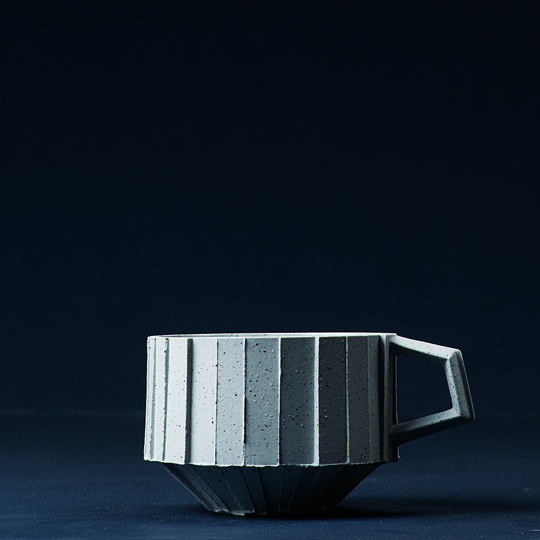 Handmade brutalist faceted ceramic cup in speckled blue stoneware, by Lea & Nicolas