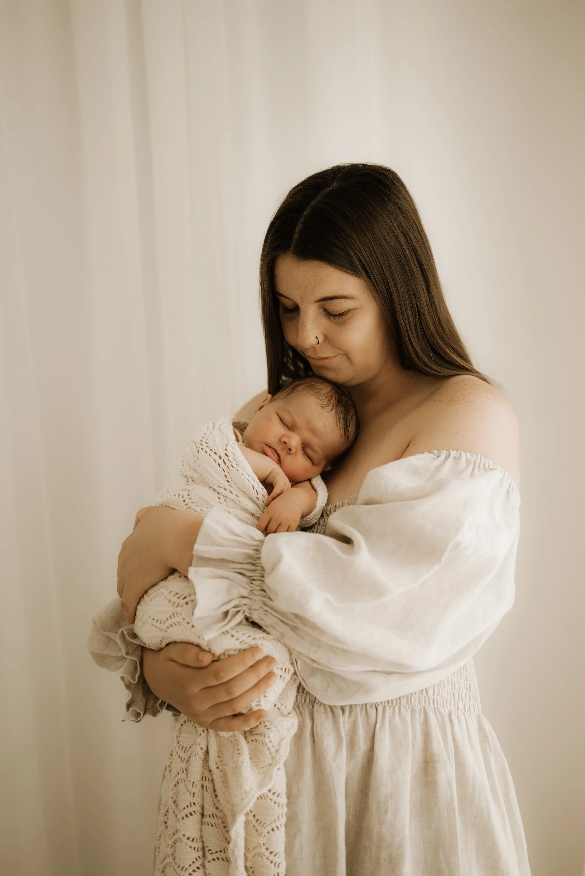 A mama with her newborn during a newborn photo shoot. Timeless, dreamy, calm, effortless newborn photography. For the mother who wants to remember it all, she wants to remember how small her baby was in the beginning. Echuca Newborn Photographer.