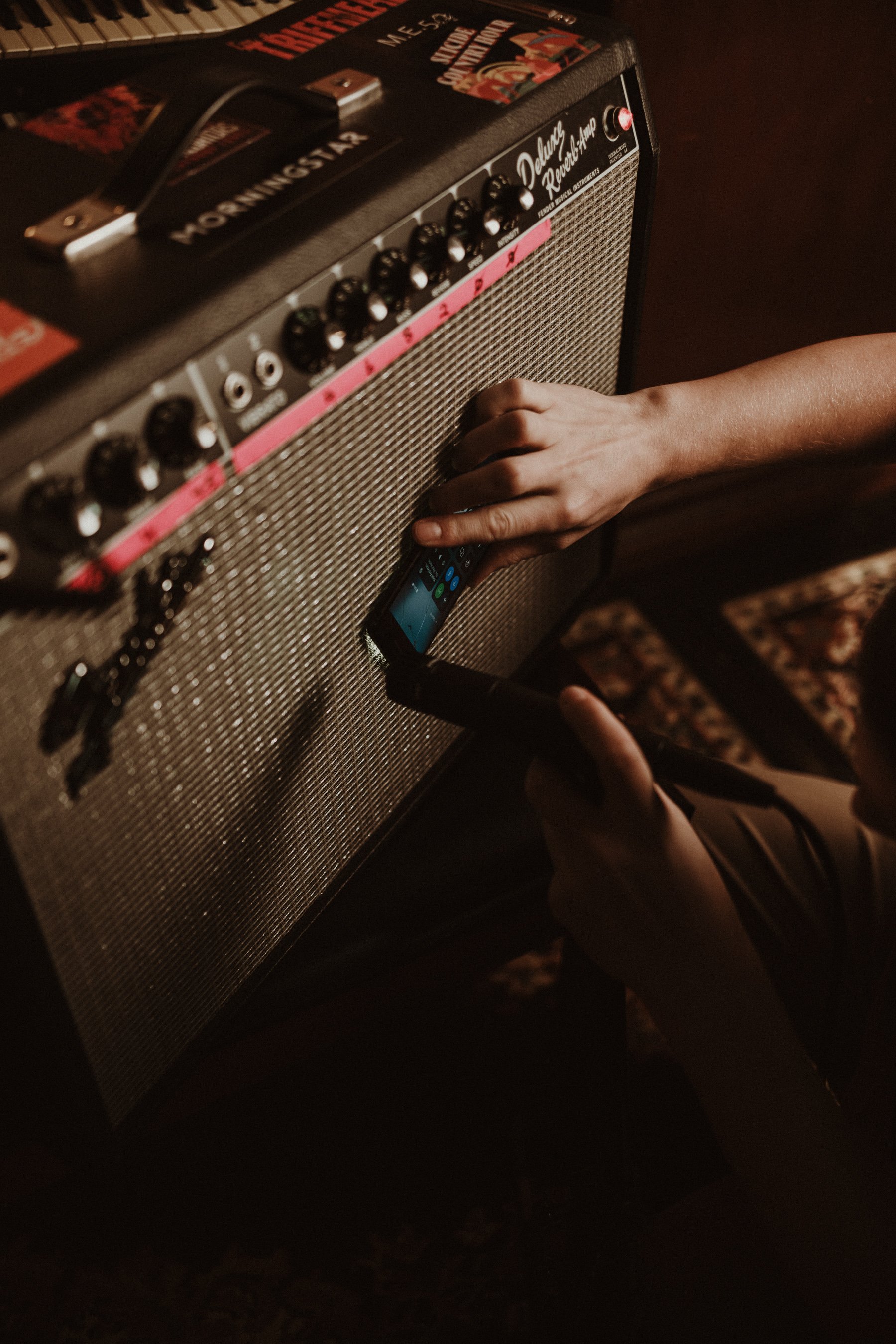 Person using a smartphone to activate or adjust an amplifier.