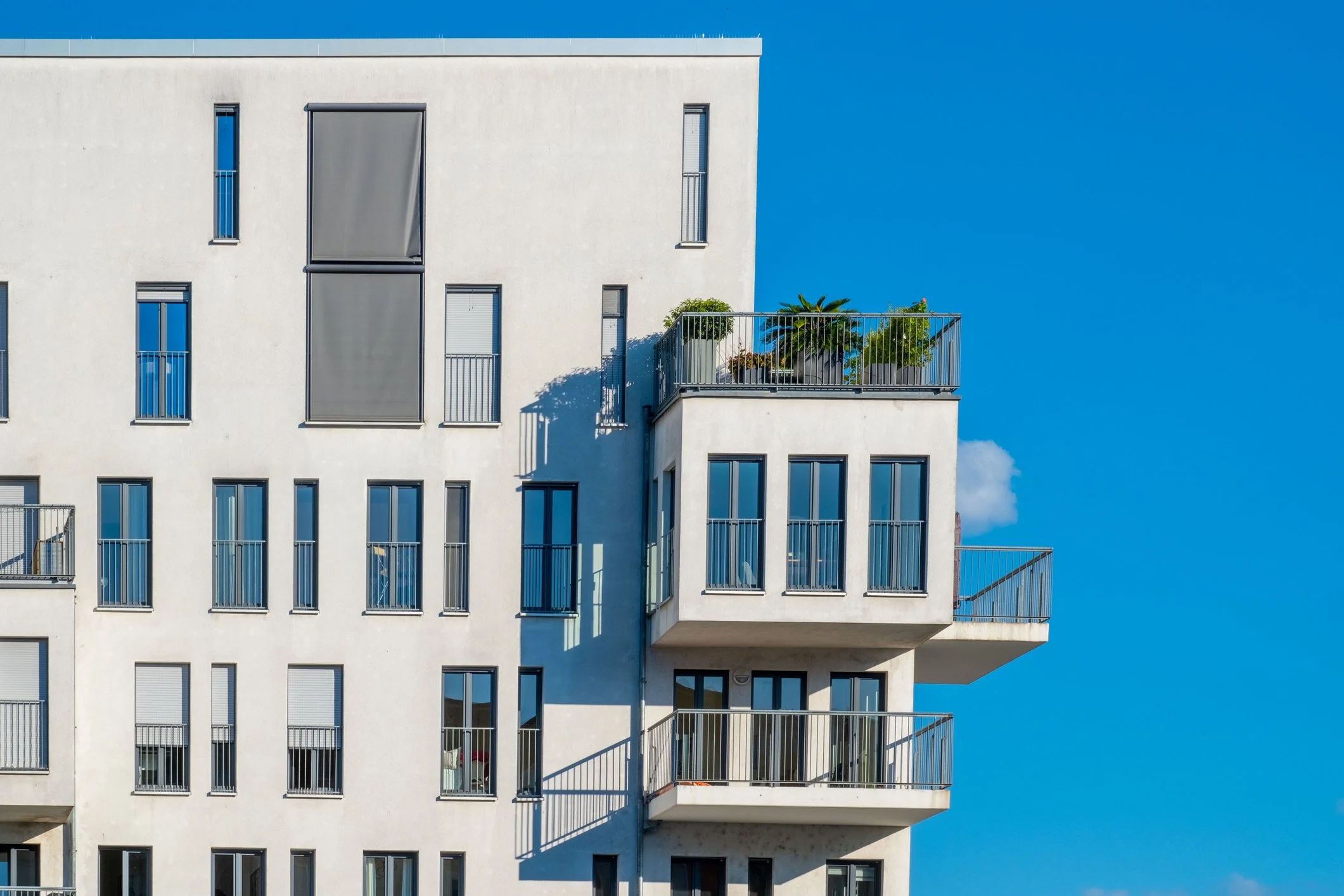 Modernes Studentenwohnheim mit gemeinschaftlichen Außenanlagen und zeitgemäßer Architektur. Das Gebäude steht beispielhaft für Wohnungsunternehmen, die Studentenwohnheime durch Energieberatung und energetische Sanierungsmaßnahmen nachhaltig modernisi
