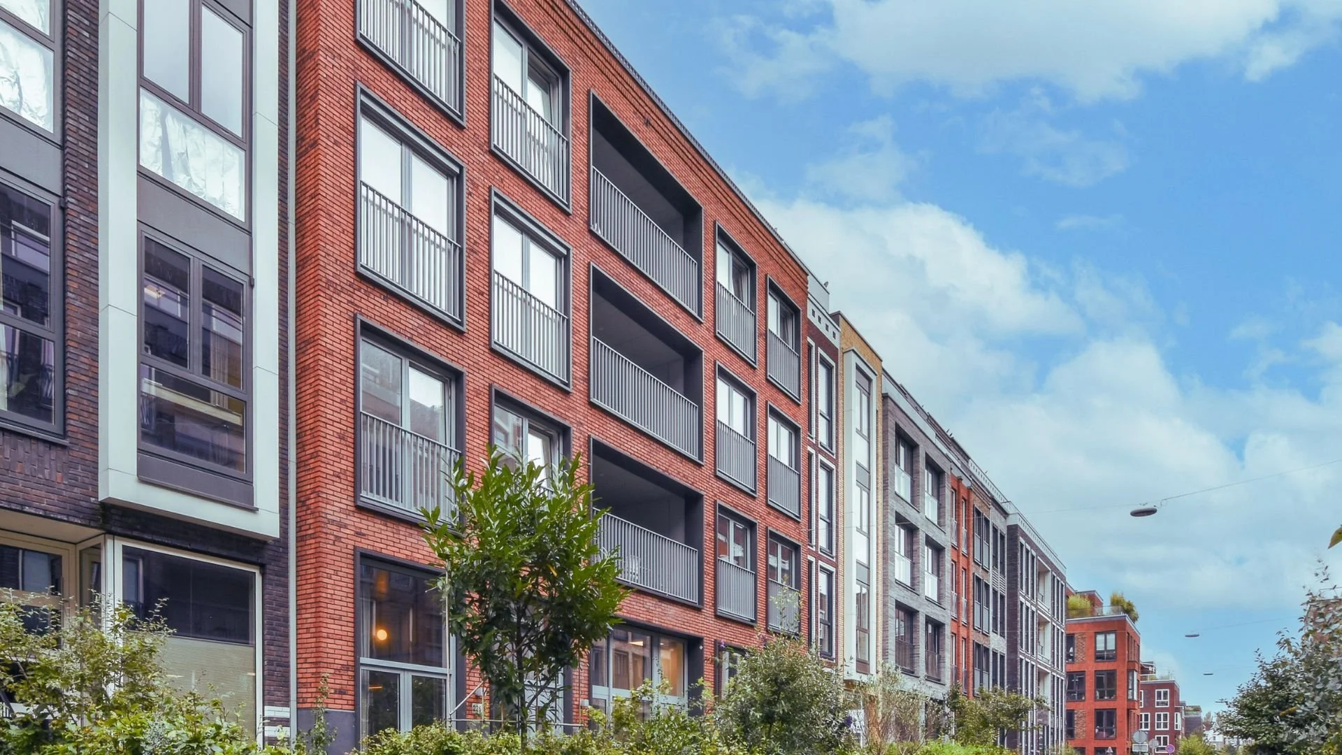 Moderne Reihenhausanlage mit mehreren Wohneinheiten und Photovoltaikanlagen auf den Dachflächen. Die Wohnanlage steht beispielhaft für Wohnungseigentümergemeinschaften mit gemeinschaftlichen Sanierungs- und Energieeffizienzprojekten.
