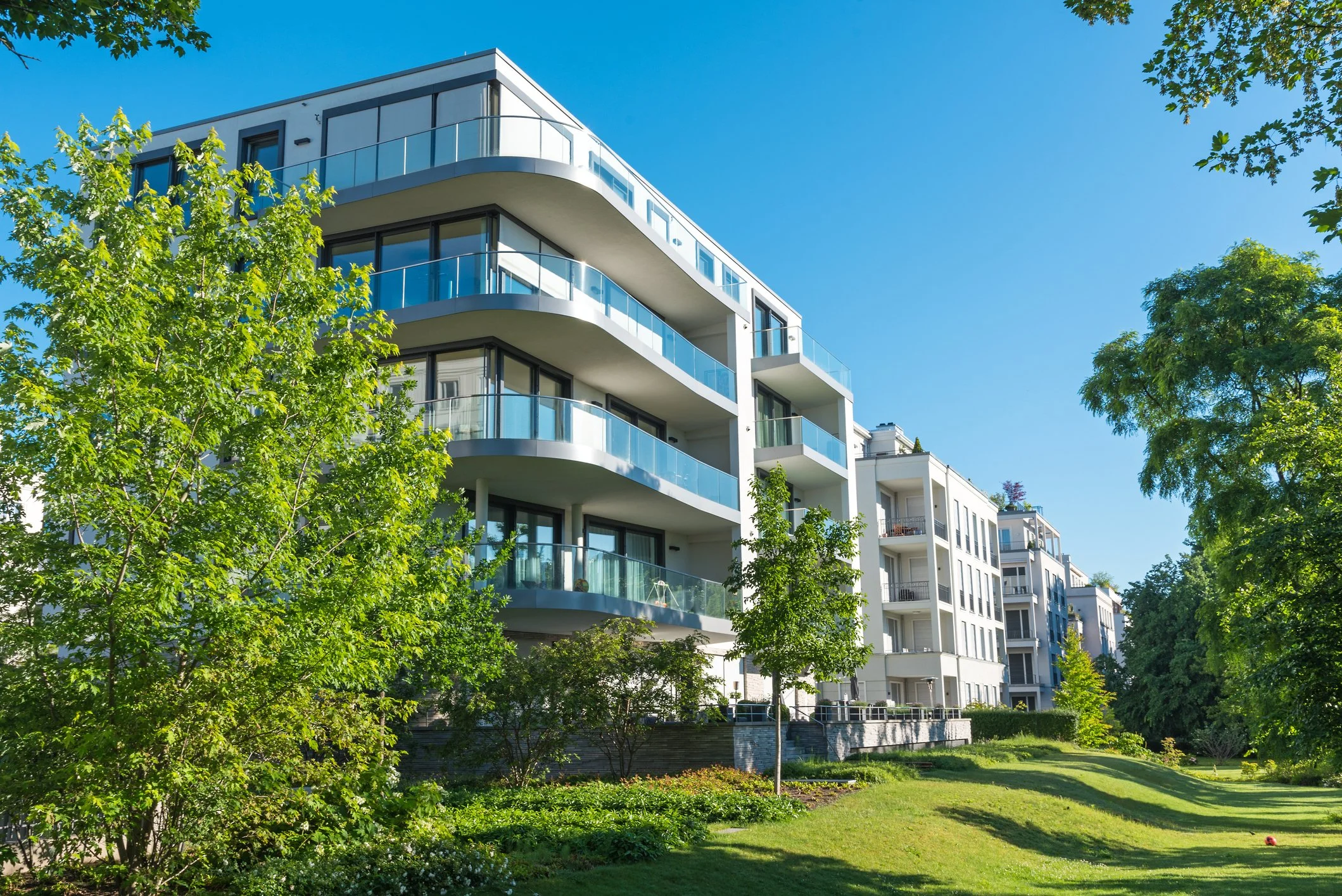Modernes Wohnquartier mit mehreren Mehrfamilienhäusern, gemeinschaftlichen Grünflächen und Wegen. Das Quartier steht beispielhaft für größere Wohnungseigentümergemeinschaften mit umfassenden energetischen Sanierungs- und Quartiersentwicklungsprojekte