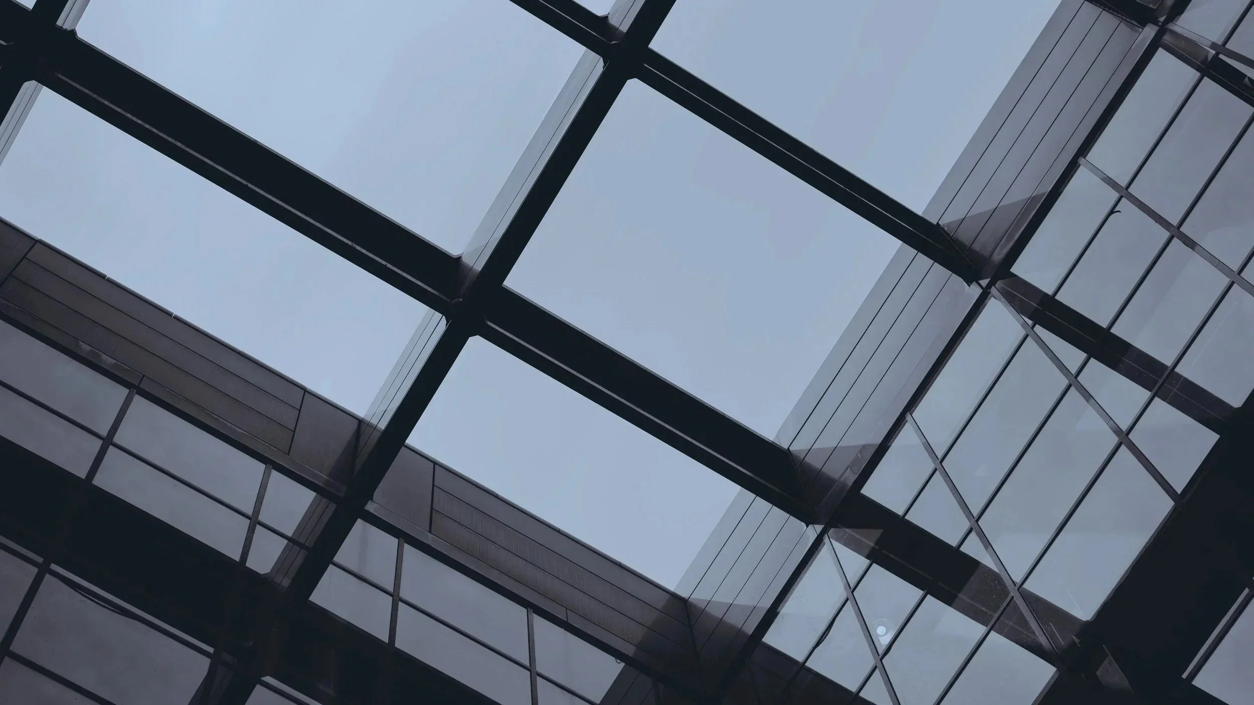 Zu sehen ist die Glasfassade eines modernen Nichtwohngebäudes als Beispiel für energetische Sanierungsmaßnahmen im Nichtwohngebäudebereich.